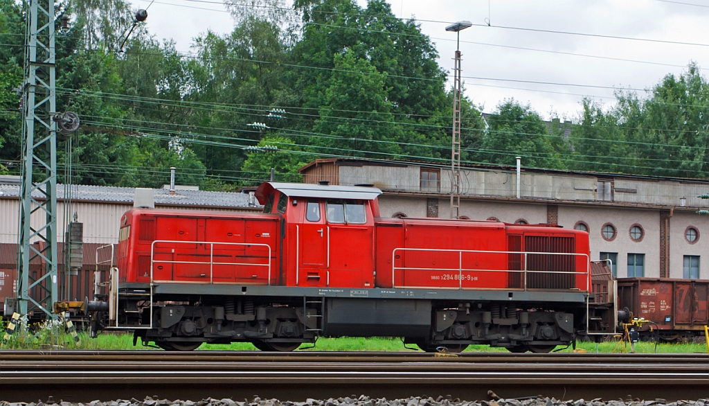 294 866-9 (V 90 remotorisiert) der DB Schenker Rail Deutschland AG steht am 16.07.2012 im Rangierbahnhof Kreuztal. 
Die Lok wurde 1973 bei MaK unter der Fabr.-Nr. 1000641 gebaut und als 290 366-4 geliefert. Die Ausrstung mit Funkfernsteuerung und Umbezeichnung in 294 366-0 erfolgte 1999, die Remotorisierung mit MTU-Motor 8V 4000 R41 und Umbezeichnung in die heutige Nr. 294 866-9 erfolgte dann 2007.
