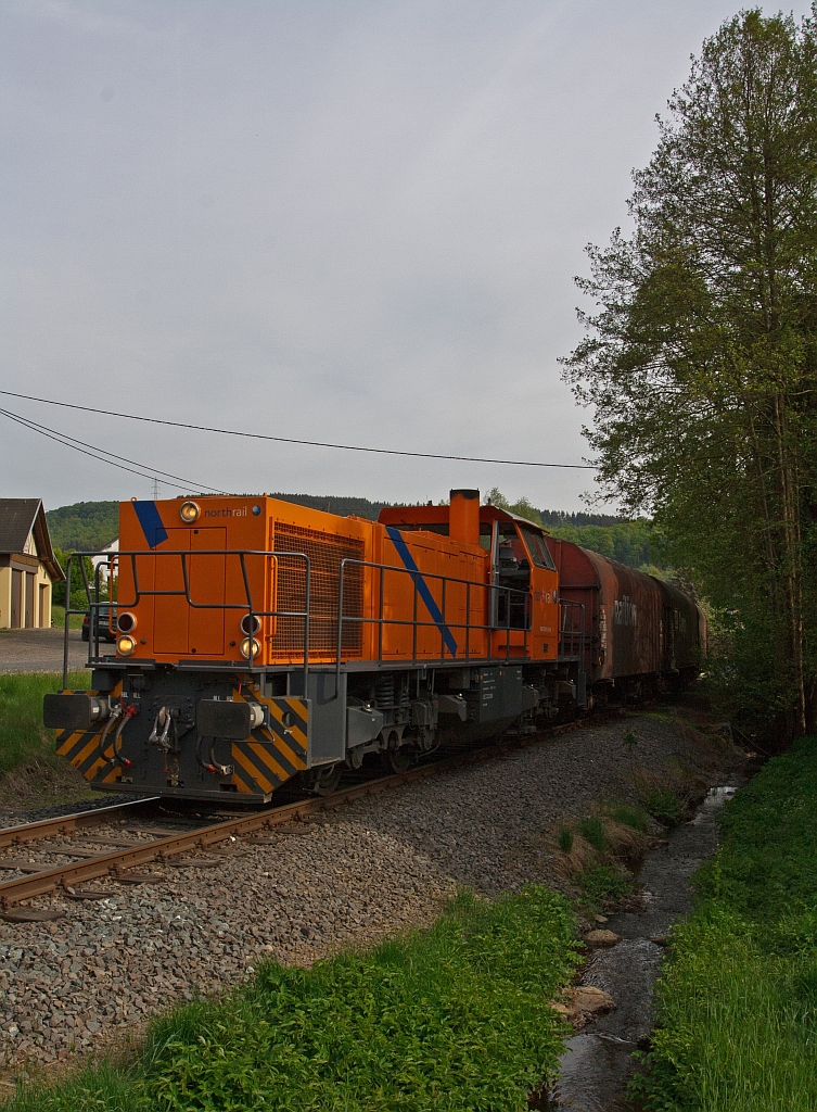 Die Kreisbahn Siegen-Wittgenstein (KSW) mit der northrail - Mietlok eine MaK G 1206 fhrt am 06.05.2011, auf KSW eigenem Gleis, mit vollem Gterzug in Neunkirchen-Salchendorf, am Bahnbergang Arbachshtte, in Richtung Pfannenberg hinauf.