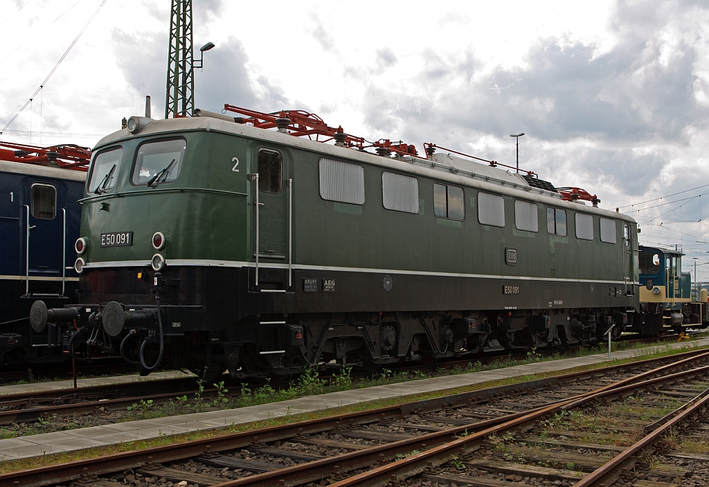 
Die schwere Gterzug-Elektrolokomotive E50 091 / 150 091-7 am 18.07.2012 im DB Museum Koblenz, in der Urspungsausfhrung. 
Diese Lok wurde 1963 bei Krupp unter der Fabriknummer 4432 gebaut, der Elektrische Teil von AEG.
Die ab 1957 gebaute E 50 (ab 1968 als Baureihe 150 gefhrt) war die erste schwere Gterzug-Ellok des Einheitslokomotivprogramms. Bis 1973 wurden in mehreren Serien insgesamt 194 Lokomotiven geliefert, die zunchst die gleichen Aufgaben wie die schweren Lokomotiven der Baureihe E 94 vor dem Zweiten Weltkrieg bernahmen und diese spter ersetzten. Wie alle Lokomotiven des Einheitslokomotivprogramms hatte die Baureihe E 50 bzw. die sptere 150 Drehgestelle als geschweite Kasten-Konstruktionen mit Drehzapfen und geschweite Kastenaufbauten mit Lftergittern.