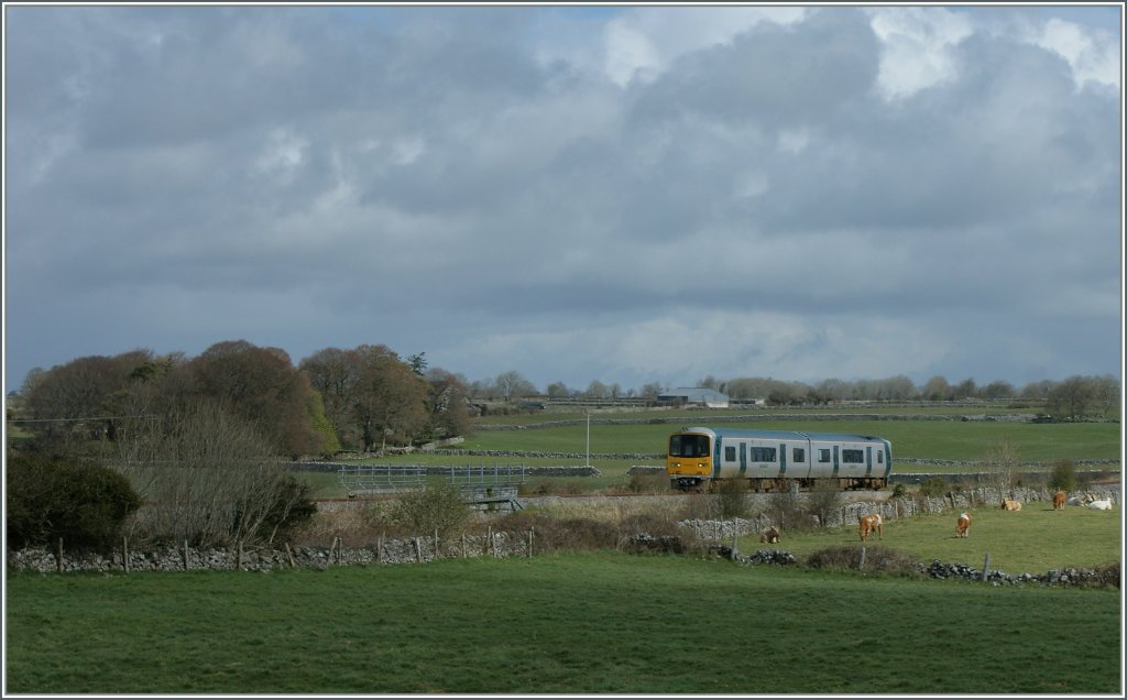 Ein Irish Rail Regionalzug auf der erst seit dem 30. Mrz 2010 nach 34 Jahren wiedererffneten Strecke (Galway) - Athenry - Ennis -(Limerick) bei Ardrahan am 21. April 2013
