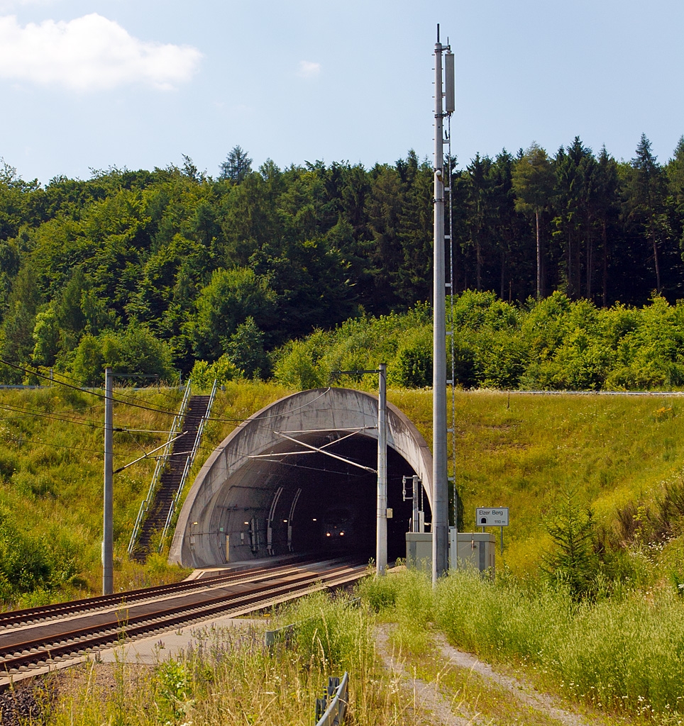 Tunnelblick am Elzer Berg am 09.07.2013 - Gleich wird es laut, hier am Sdportal bei km 101,6 wenn der ICE 3 heraus schiet. 

Der Tunnel Elzer Berg ist ein 1.110 m langer Eisenbahntunnel der Schnellfahrstrecke Kln–Rhein/Main (KBS 472). Er liegt am Elzer Berg, im Bereich der mittelhessischen Gemeinde Elz und trgt daher seinen Namen.
 
Die Rhre kann planmig mit 300 km/h befahren werden.
