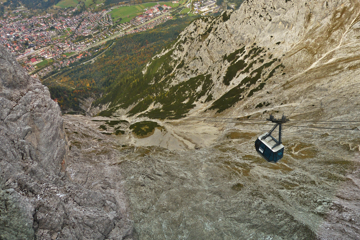 . Aussicht von der Bergstation der Karwendelbahn (2244 Meter) auf eine talwrts fahrende Gondel und auf Mittenwald (933 Meter). 05.10.2015 (Hans)