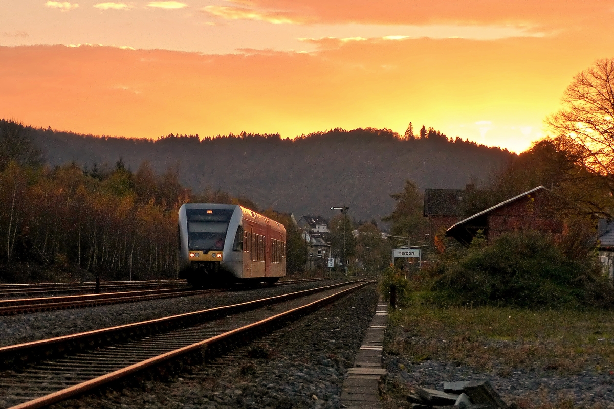 . Sonnenuntergang in Herdorf - Whrend die Sonne sich am 01.11.2014 sehr eindrucksvoll verabschiedet, verlsst ein Stadler GTW 2/6 der Hellertalbahn den Bahnhof von Herdorf. (Jeanny)