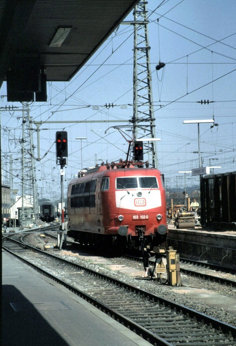 103 102-0in orientrot in Nürnberg Hbf im Mai 1990. Die 103 rangiert in Nürnberg Hbf um den EK Rheingold Salonwagen (mit Buckel), an den IC anzuhängen, der die Fahrgäste des ausgefallenen VT_12.5 (Eierkopf) aus Braunschweig für die Fahrt nach Österreich angehängt zu werden.