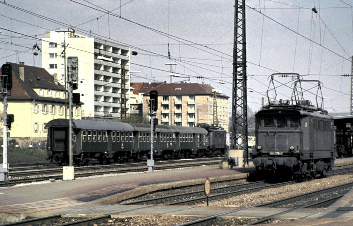 144 076-5 setzt in Pforzheim um; im Bahnhofsbereich steht 144 035-3 mit Umbauwagen und wartet auf den Einsatz, am 1704.1982.