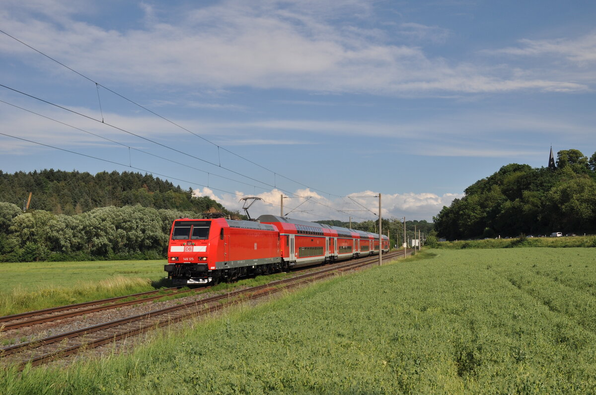 146 125, welche zu diesem Zeitpunkt noch im Neulack glänzte, war am 21.07.2021 mit ihrem RE20 nach Limburg(Lahn) unterwegs und lässt dabei den Ort Niederbrechen hinter sich.