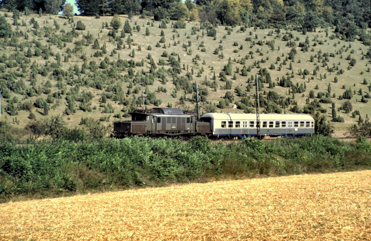 194 018-8 mit einem Silberling, dem Samstag-Schülerzug Geislingen - Ulm während der Ferienzeit bei Urspring am 28.08.1985.