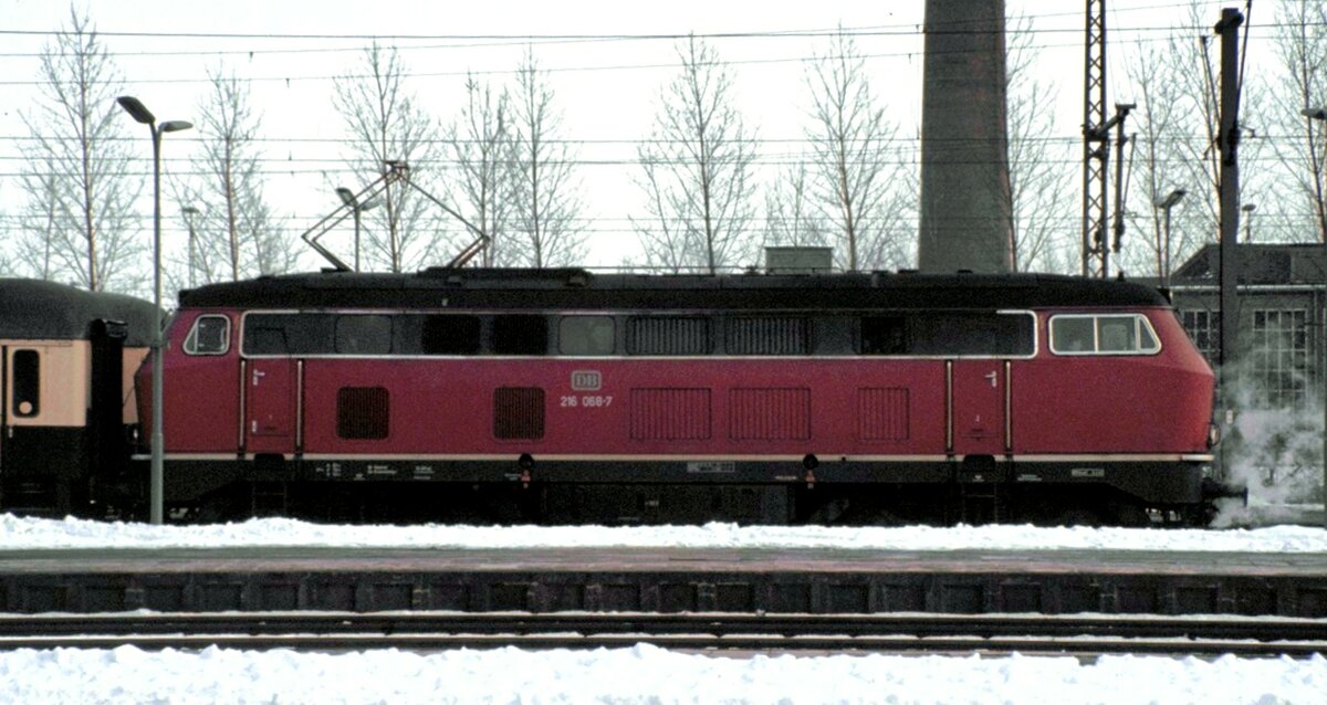 216 068-7 in Braunschweig - Ja, es ist eine Diesellok, auch wenn diese vorn dampft (Dampfheizung) und oben auf dem Dach ein Pantograph sichtbar ist von einer Ellok, die hinter der Lok steht. am 14.02.1983.