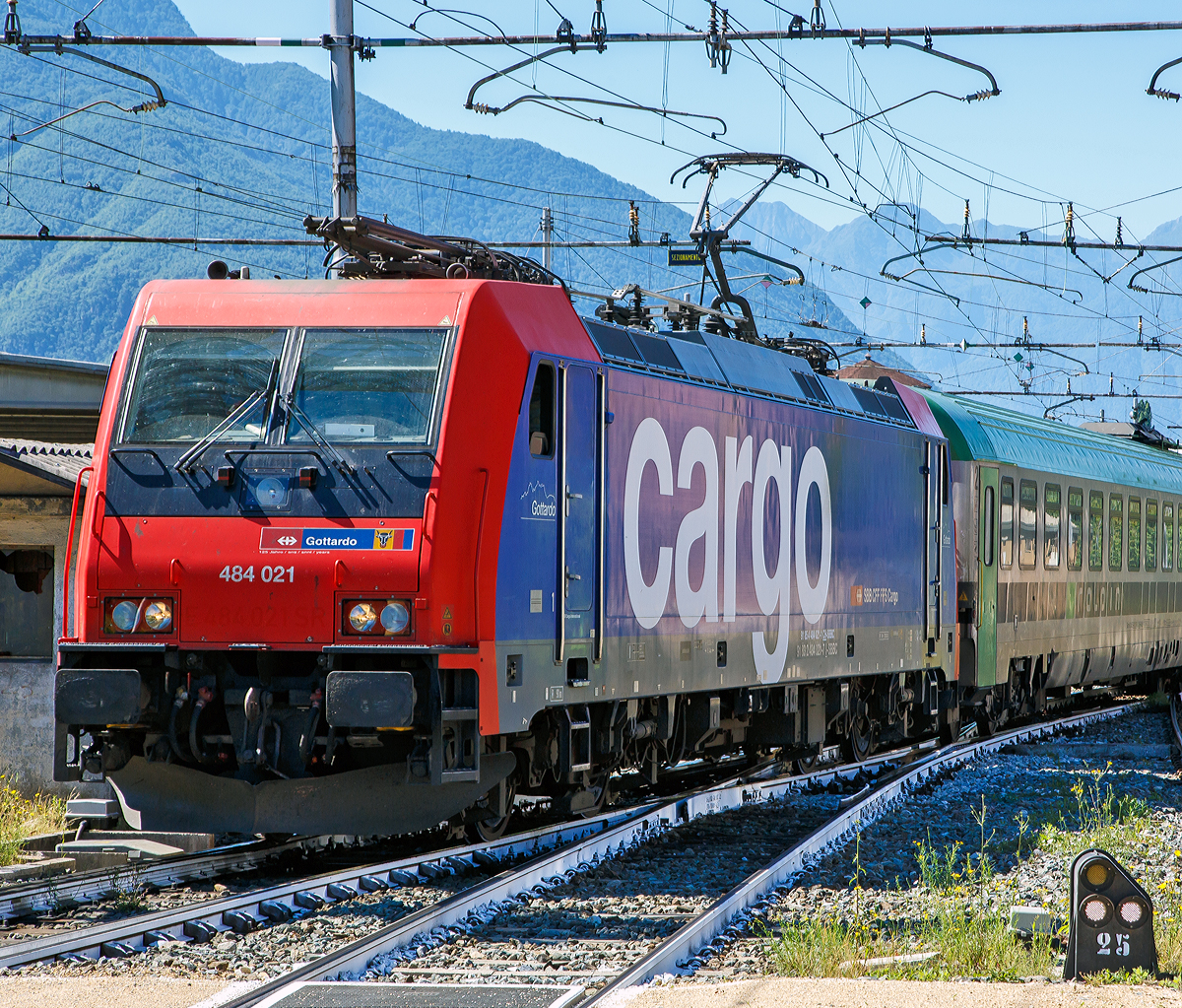 Als Lokportrait……
Die SBB Cargo Re 484 021  Gotthardo  (91 85 4 484 021-1 CH-SBBC / 91 83 2 484 021-7 I-SBBC) kommt am 22.06.2016 mit einem Ralpin-Zug (Rola-Zug) im Bahnhof Domodossola aus Richtung Süden an. Im Domodossola wird sie dann von einer BLS Re 485 (Traxx F140 AC1) abgelöst und den Zug dann, via dem Simplon-Tunnel nach Freiburg im Breisgau bringt.

Die TRAXX F140 MS2 wurde 2006 von Bombardier in Kassel unter der Fabriknummer 34297 gebaut. Sie hat die Zulassung und Zugsicherung für die Schweiz und Italien.

Die Re 484 der Schweizerischen Bundesbahnen (SBB) ist eine Baureihe von Vierstrom-Elektrolokomotiven, die von Drehstrom-Asynchronmotoren angetrieben wird. Die Lokomotiven stammen aus der TRAXX-Familie von Bombardier Transportation und tragen die Herstellerbezeichnung TRAXX F140 MS2.

2003 entschied sich SBB Cargo als erster Betreiber in Europa, die TRAXX-Plattform von Bombardiers (1,5kV / 3kV DC + 15kV / 25kV AC) mit vier Spannungen zu bestellen. Bis dahin existierten diese Maschinen nur auf Papier. Für Bombardier stellte der Auftrag einen solchen Meilenstein dar, dass für die SBB Cargo 484 001, die erste TRAXX-Lokomotive, die auf allen vier wichtigsten europäischen Fahrleitungssystemen eingesetzt werden konnte, die Seriennummer 34000 reserviert wurde.

Die SBB Cargo Re 484-Serie wurde in drei Tranchen ausgeliefert. Der erste Auftrag mit der Re 484 001-012, der im Jahr 2005 abgeschlossen wurden. Im selben Jahr wurde auch der erste Folgeauftrag von sechs Maschinen abgegeben (Re 484 013-018). 2007 wurden drei zusätzliche Maschinen gebaut (Re 484 019-021).
Die Maschinen werden ausschließlich für Dienstleistungen in Italien und der Schweiz seit Lieferung verwendet. Sie verfügen entsprechend über eine 15 kV 16,7 Hz Wechselstromausrüstung (AC) und eine 3 kV Gleichstromausrüstung (DC). Die Umrichteranlage würde auch den Einsatz unter den anderen in Europa verwendeten Stromsystemen 25 kV 50 Hz (AC) und 1,5 kV (DC) erlauben, jedoch ist die Lokomotive nicht mit den dafür notwendigen Zugsicherungssystemen ausgerüstet.

Die Re 484 ist eine Weiterentwicklung der TRAXX-Baureihe F140 AC1 (DB BR 185, SBB Re 482, u. a.), gegenüber welcher sie als augenfälligste Änderung einen überarbeiteten Lokkasten besitzt. Die Änderung erfolgte, um den neuen, strengeren Sicherheitsnormen bezüglich Crashfestigkeit zu genügen. Sie ist am einfachsten an der Lokfront zu erkennen, welche im Bereich der unteren Signalleuchten gerade nach unten verläuft und nicht eingezogen ist wie bei der ersten Serie der BR 185. Außerdem ist unterhalb der Stirnfenster eine Klappe für den Ausbau der Klimaanlage angebracht und die Anzahl der Griffstangen im Frontbereich erhöht worden. Die Lokomotive erhielt auch eine neue wassergekühlte IGBT Umrichteranlage.

TECHNISCHE DATEN:
Spurweite:  1.435 mm (Normalspur)
Achsfolge:  Bo'Bo'
Gebaute Stückzahl:  21
Umgrenzungsprofil: UIC 505-1
Länge über Puffer: 18.900 mm
Virtueller Drehgestellmittenabstand: 10.440 mm
Radsatzabstand im Drehgestell: 2.600 mm
Höhe:  4.283 mm
Breite: 2.977 mm
Dienstgewicht: 85,4 t
Radsatzlast: 21.5 t
Höchstgeschwindigkeit: 140 km/h
Stundenleistung: 5.600 kW
Anfahrzugkraft: 300 kN
Max. elektrische Bremskraft:  240 kN 
Leistung elektrische Bremse:  5.6 MW (bei AC) / 2.6 MW (bei DC)
Treibraddurchmesser:  1.250 mm (neu)/ 1.170 mm (abgenutzt)
Motorentyp:  Drehstrom-Asynchronmotoren
Stromrichter:  2 x MITRAC TC 3300
Anzahl der Fahrmotoren:  4
Antrieb: Tatzlagerantrieb
Stromsystem: 15 kV 16,7 Hz Wechselstrom (AC) und 3 kV Gleichstrom (25 kV 50 Hz AC und 1,5 kV DC wären aber auch möglich)
Anhängelasten: bis 6 Promille 1.950 t, bis 12 Promille 1.620 t und bis 26 Promille 700 t 
Fördervolumen des Kompressors: 2.400 l/min
Hauptluftbehältervolumen: 800 l
Besonderheiten: Automatische Feuerlöschanlage, Rückseheinrichtung (Videokameras)