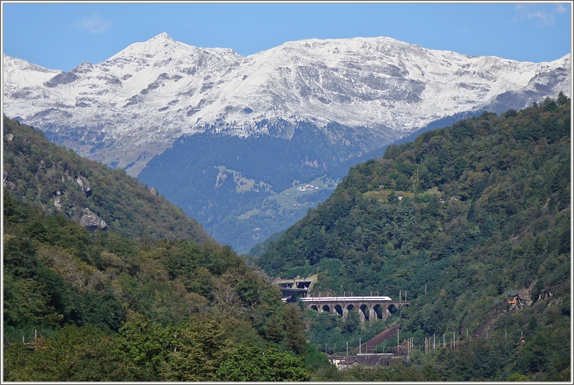 Der ICN 676 auf der Fahrt von Lugano nach Basel auf dem Pianotondo-Viadukt vor der beeindruckenden Kulisse des frisch verschneiten Gotthardmassiv. (24.09.2015)