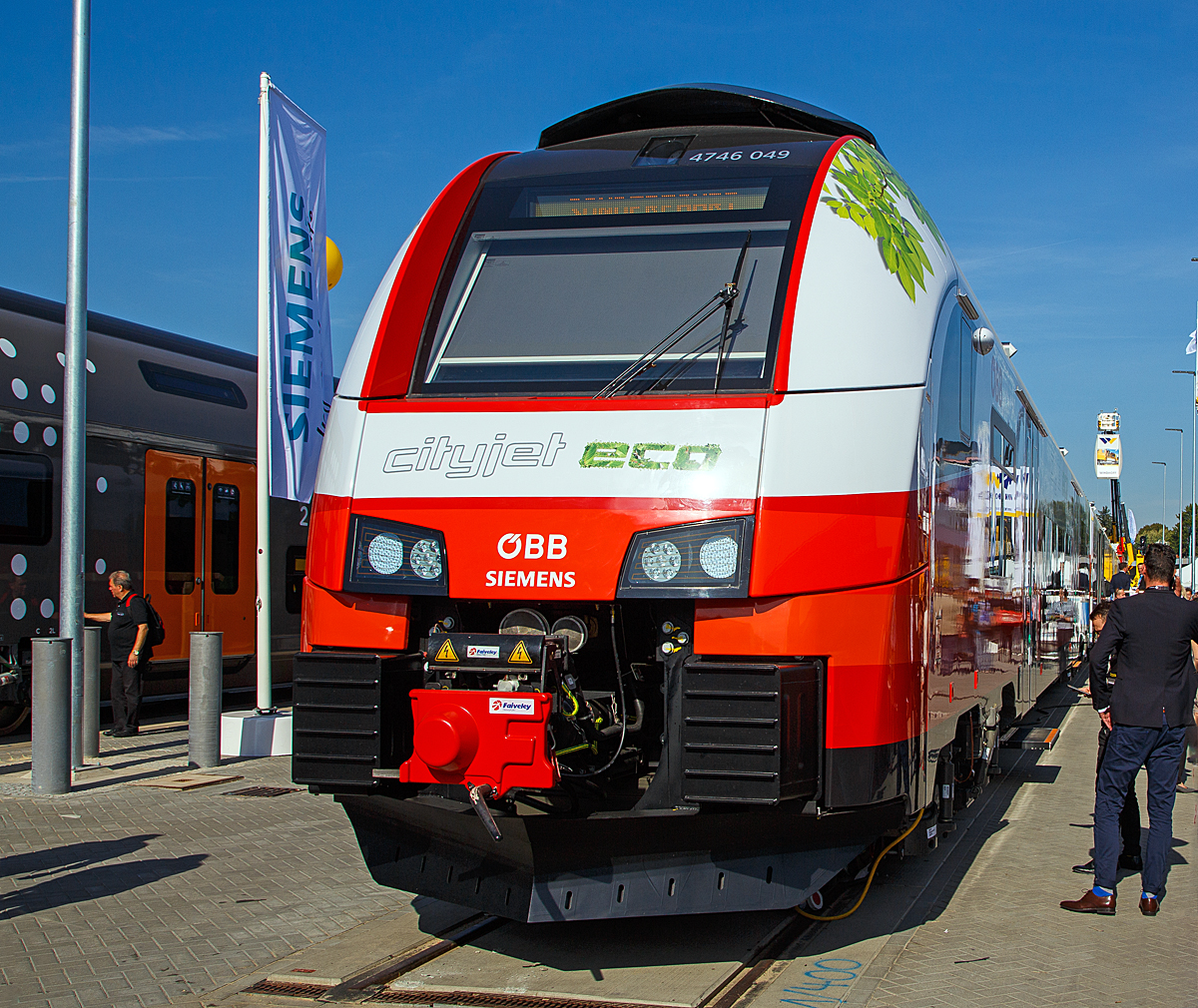 
Der ÖBB Cityjet eco eine Innovation auf Schiene....
Siemens und ÖBB präsentierte auf der InnoTrans 2018 in Berlin (hier 18.09.2018) mit dem ÖBB 4746 049 den Prototyp ÖBB Cityjet eco, ein elektro-hybriden Siemens Desiro ML, eine Innovation auf der Schiene.

ÖBB und Siemens setzen mit dem Cityjet eco neue Maßstäbe auf nicht-elektrifizierten Strecken im Nah- und Regionalverkehr. Mit diesem Zug kann künftig eine nachhaltige Alternative zu Dieselfahrzeugen abseits der Hauptverkehrsrouten geboten werden.

Der Cityjet eco ist eine Alternative für nicht-elektrifizierte Strecken, die heute größtenteils mit dieselbetriebenen Personenzügen befahren werden. Siemens entwickelt einen elektro-hybriden Batterieantrieb, der es möglich macht, dass der Zug auf elektrifizierten Strecken Energie über seinen Stromabnehmer aufnimmt und gleichzeitig in den neu mitgeführten Batterien speichert. Diese Energie kann für den Betrieb auf nicht-elektrifizierten Strecken genutzt werden. Sobald der Zug die elektrifizierte Strecke verlässt, speisen die Batterien das Energieversorgungssystem des Zuges (bis zu ca.80 km). Gemeinsam mit den ÖBB wird diese Technologie nun in einem Pilotprojekt in den kommenden Monaten in der Praxis auf Herz und Nieren geprüft und zur Serienreife weiterentwickelt.

Das Pilotprojekt wird mit einem Zug aus der aktuell für die ÖBB laufenden Serienproduktion des Siemens Desiro ML umgesetzt. Die Bauweise des Fahrzeuges ermöglicht es, zusätzliche Dachlasten aufzunehmen. Damit sinkt die ansonsten branchenweit übliche Liefer- und Fertigungszeit eines Neufahrzeugs von bis zu 36 Monaten auf weniger als die Hälfte.

Die laufende Serienfertigung des ÖBB Cityjets eröffnete die Möglichkeit einer kurzfristigen Entnahme eines Fahrzeugs sowie dessen Umbau zu einem Akku-Triebzug und kurzfristigen Einsatz als Prototypzug im Rahmen einer Erprobungsphase. Die Batterieanlage am Mittelwagen des umgebauten Triebfahrzeuges ÖBB 4746 049 / 549 der Serie DESIRO ML umfasst drei Batteriecontainer, zwei DC/DC-Steller, einen Batteriekühler sowie weitere Elektronikbauteile. Zum Einsatz kommen Lithium-Titanat-Batterien (LTO-Technologie). Diese modifizierten Batterien erlauben – verglichen mit herkömmlichen Lithium-Ionen-Batterien – deutlich höhere Ladeströme zur Schnellladung. Die Lebensdauer der Batterien soll bei Serienreife rund 15 Jahre betragen, was zur Folge hätte, dass sie über die Gesamtnutzungsdauer des Zuges nur einmal gewechselt werden müssen.

TECHNISCHE DATEN:
Spurweite:1.435 mm
Achsfolge: Bo‘Bo‘+2‘2‘+Bo‘Bo‘
Länge (über Kupplung): 75.152 mm
Drehzapfenabstand: 16.240 mm
Achsabstand im Drehgestell: 2.300 mm
Antriebsleistung: 2.600 kW (ca. 1.300kW im Batterie-Modus)
Höchstgeschwindigkeit: 140 km/h (120 km/h im Batterie-Modus)
Installierte Batteriekapazität: 528 kWh
Anfahrbeschleunigung1,0 m/s² (0.77 m/s² im Batterie-Modus)
Stromsystem: 15 kV 16,7 Hz AC / 25 kV, 50 Hz AC
Fußbodenhöhe: 600 mm
Fahrgastkapazität: 244 Sitzplätze 
Max. Achslast: kleiner 17 t 

