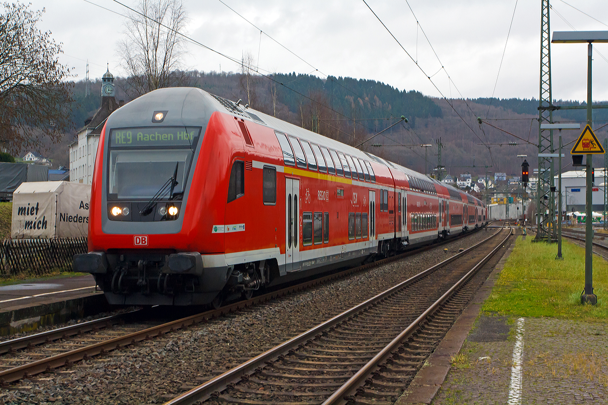 
Der RE 9 - Rhein-Sieg-Express (Siegen – Köln - Aachen) fährt am 21.12.2014 Steuerwagen voraus mit 6 DoSto durch den Haltepunkt Niederschelden, die Schublok war 120 207-6.