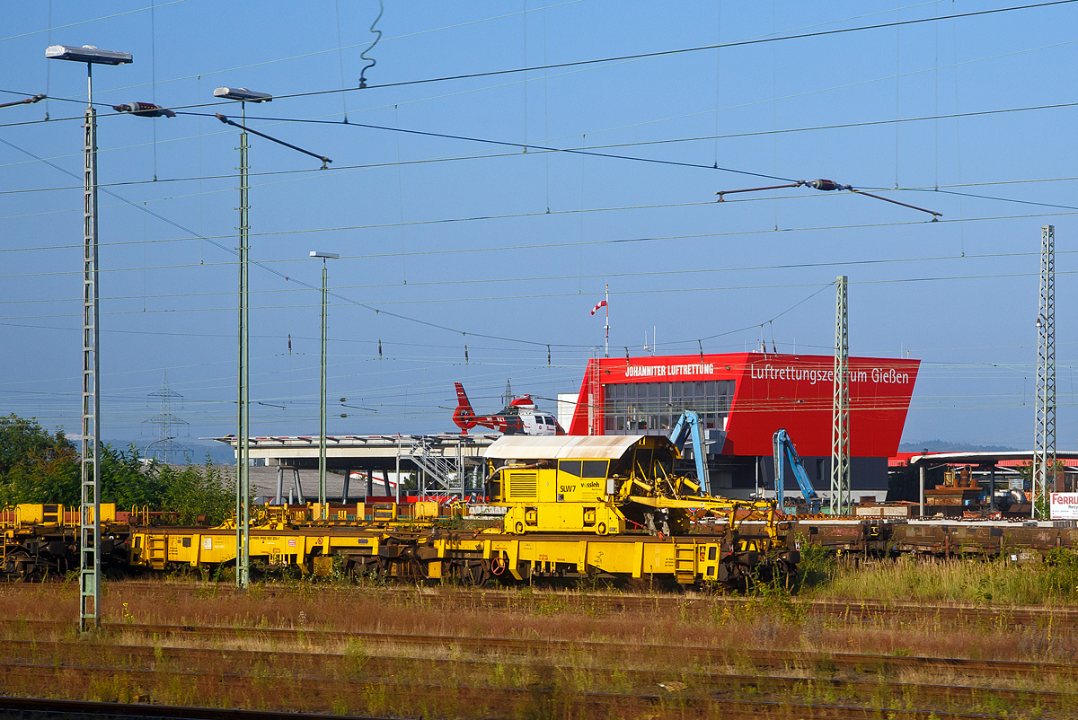 Der Schienenladewagen SLW 7, Schweres Nebenfahrzeug Nr. 97 30 08 907 57-6, der Vossloh Mobile Rail Services GmbH abgestellt mit Lanschienentransport am 05.09.2021 beim Bahnhof Gießen. Aufgenommen aus einem Zug heraus.

Der Schienenladewagen wurde 2007 von Maschinen- und Anlagenservice MAS GmbH in Guben unter der Fabriknummer 01/07 gebaut, wobei der Schienenmanipulator von Robel stammt und überarbeitet wurde. Das Eigengewicht beträgt 47 t, die Höchstgeschwindigkeit 120 km/h und der kleinste befahrbare Gleisbogen 80 mm.

Der Schienenladewagen dient zum Be- und Entladen von bis 180 m langen Schienen, auf/von den Schwellenköpfen bzw. in/aus Gleismitte. Der Einsatz erfolgt in Kombination mit Langschienentransporteinheiten der Bauart Robel. Die Be- bzw. Entladeleistung beträgt ca. 900 bis 1.400 m Gleis/Stunde.