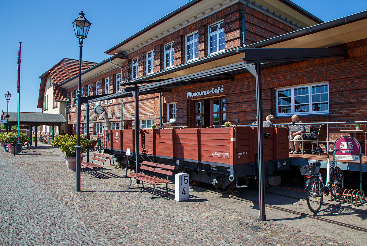 Der Terassenwagen, ein vierachsiger offener Güterwagen ex DR 98-02-55 der Gattung OOw, am Molli-Museums-Café beim Bahnhof Ostseebad Kühlungsborn-West (bis 1938 Ostseebad Arendsee) der Mecklenburgischen Bäderbahn Molli am 15.05.2022. Davor der Km-Stein (15,4 km) der Strecke.

Der Wagen wurde 1911 von der Waggonfabrik Wismar für die DHE - Doberan-Heiligendammer-Eisenbahn (ab 1. April 1920 zur Deutschen Reichsbahn), gebaut. Von 2005 bis 2006 wurde er rekonstruiert und dient seit 2006 als Terassenwagen des Molli-Cafes.

TECHNISCHE DATEN:
Spurweite: 900 mm
Gattung: OOw
Anzahl der Achsen: 4
Länge über Puffer: 8.800 mm
Drehzapfenabstand: 5.000 mm
Achsabstand im Drehgestell: 1.300 mm
Länge der Ladefläche: 8.000 mm
Ladefläche: 16 m²
Eigengewicht: 6.400 kg
Tragfähigkeit: 14,3 t
