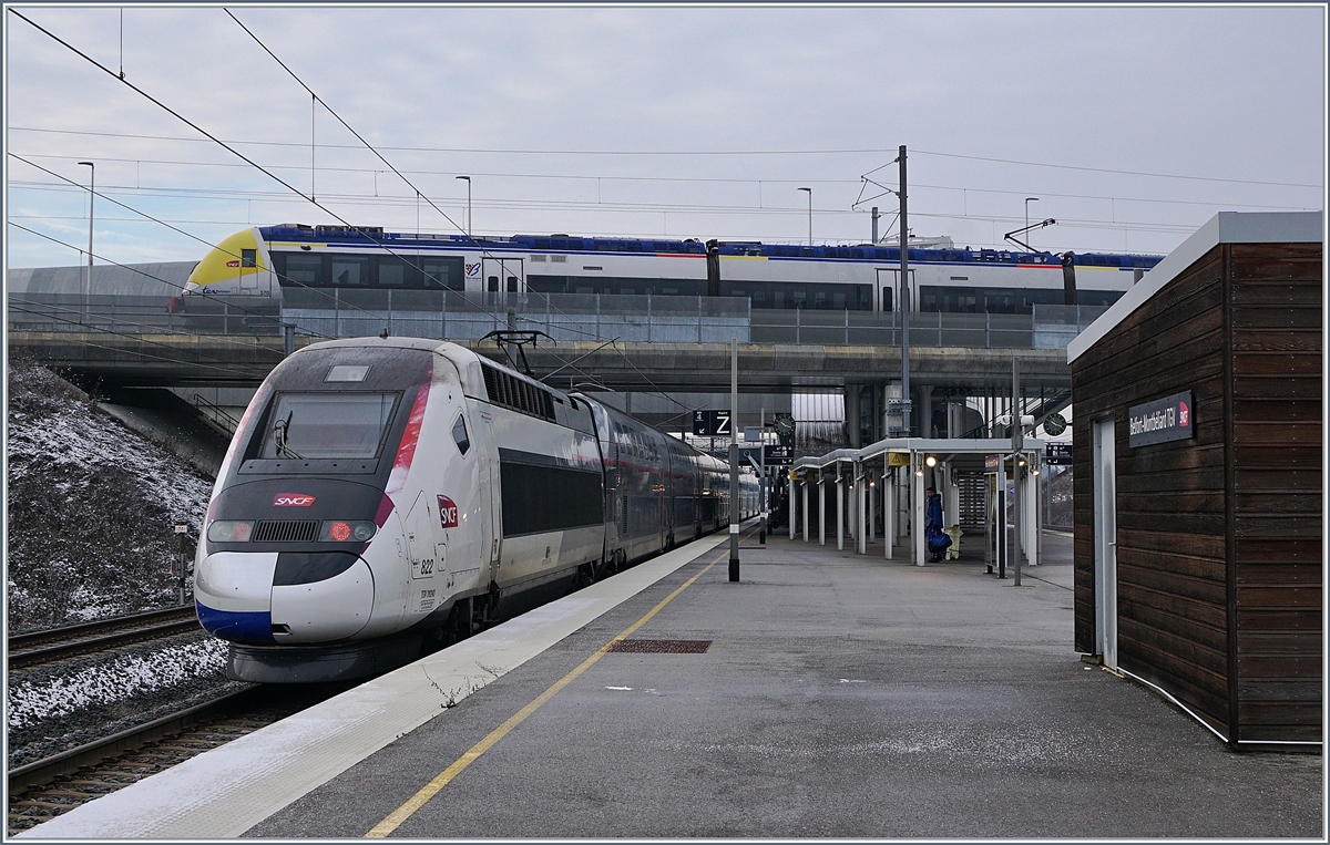 Der TGV 822 mit den Triebköpfen 310244 (führend) und 310243 (schiebend) hat den Bahnhof  Belfort-Montbéliard TGV erreicht. Der Euroduplex ist als TGV 9880 von Luxembourg (ab 07:24) nach Montpellier Saint-Roch (an 15:03) unterwegs. 
Darüber, im Bahnhof Meroux steht er SNCF Z 25570/27569 der als TER 895055 von Belfort hier angekommen ist und nach einer knappen Stunde als TER 895056 wieder nach Belfort zurückfährt.
11. Jan. 2019