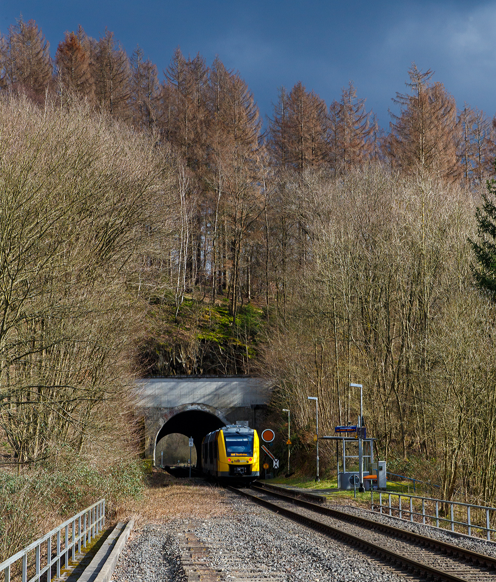 
Der VT 504 (95 80 1648 104-5 D-HEB / 95 80 1648 604-4 D-HEB) ein Alstom Coradia LINT 41 der neuen Generation der HLB (Hessische Landesbahn GmbH), fährt als  RB 96  Hellertalbahn  (Betzdorf/Sieg - Herdorf - Neunkirchen) am 07.03.2020 durch den Hp Herdorf-Königsstollen (Bedarfshaltestelle), gleichdarauf geht es durch den 137 m langen Herdorfer Tunnel. 

Rechts das dreibegriffige Einfahrvorsignal (für den Bf Herdorf) steht auf Signal Vr 2 – Langsamfahrt erwarten (Die Runde orange Scheibe mit schwarzem Ring und weißem Rand steht senkrecht, der Flügel, mit gleicher Farbanordnung wie die Scheibe, zeigt mit der Spitze nach rechts abwärts. Rechts daneben die Vorsignaltafel (Signal Ne 2). So wird der Standort desVorsignales eindeutig gekennzeichnet.