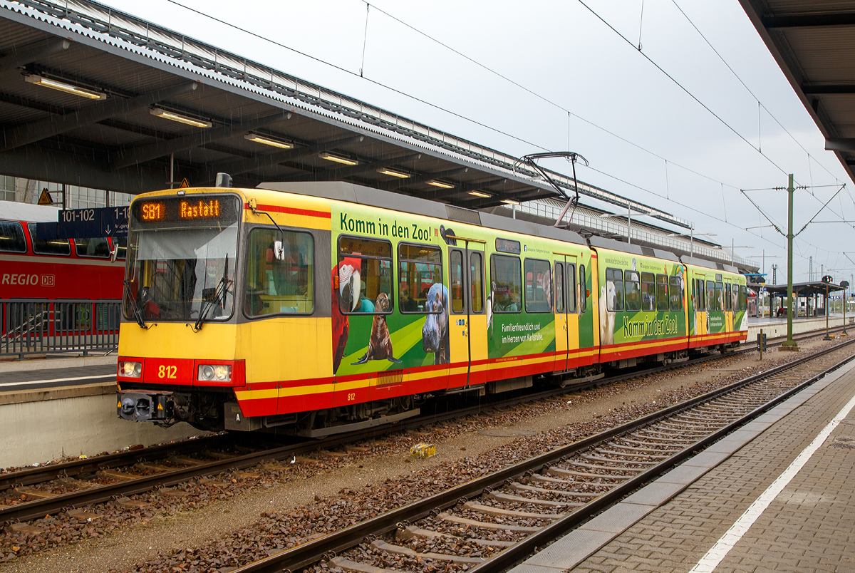 Der Zweisystem-Stadtbahn-Triebzug 812 der VBK Verkehrsbetriebe Karlsruhe GmbH (VBK 812) steht am 09.09.2017, als Linie S 81nach Rastatt, zur Abfahrt im Hbf Karlsruhe bereit.

1991 wurde nach mehrjhriger Entwicklungsarbeit die erste Serie Zweisystem-Stadtbahnfahrzeug ausgeliefert. Mit diesen Fahrzeugen begann eine neue ra im Schienenverkehr. Denn diese Fahrzeuge sind in der Lage, sowohl im Netz der DB, im Eisenbahnnetz der AVG als auch im Straenbahnnetz der VBK zu fahren.

Um dieses zu knnen, sind sie in zahlreichen Bereichen mit zwei Systemen, dem der DB wie dem von AVG und VBK ausgestattet, z. B verfgen sie ber zwei unterschiedliche Funksysteme und ber zwei unterschiedliche Sicherungssysteme. Der Clou der Fahrzeuge aber ist die automatische Umschaltung von einer Strom- und Betriebsart auf die andere. Der Triebfahrzeugfhrer muss nichts machen, das Fahrzeug schaltet an den Systemwechselstellen selbststndig von 750 V auf 15 KV oder umgekehrt um.

Bei den Fahrzeugen handelt es sich um achtachsige, dreiteilige Gelenktriebwagen mit zwei Jakobsdrehgestellen. Die beiden ueren konventionellen Drehgestelle am Bug und Heck werden von zwei Gleichstrommotoren mit 280 kW angetrieben. Der mechanische Aufbau der Fahrzeuge ist von den seit 1983 in Karlsruhe eingesetzten Stadtbahnen GT6-80C und GT8-80C abgeleitet, welche selbst vom DUEWAG Stadtbahnwagen Typ B abgeleitet wurden. 

Im Gegensatz zu diesen Stadtbahnen handelt es sich allerdings um Zweirichtungswagen, da im DB-Netz im Allgemeinen keine Wendeschleifen existieren. Daher verfgen sie ber zwei Fahrerkabinen und jeweils vier Doppeltren auf jeder Fahrzeugseite. Die Wagenksten sind in Ganzstahlbauweise ausgefhrt. Scharfenberg-Kupplungen erlauben einen Betrieb in Mehrfachtraktion, darunter Doppel- und Dreifachtraktionen sowie gemischte Doppeltraktionen mit den GT6-80C, GT8-80C und GT8-100D/2S-M.

Die elektrische Ausrstung der GT8-100C/2S wurde von den GT8-80C bernommen und besteht aus je einem Gleichstrom-Fahrmotor pro Antriebsdrehgestell sowie einer Gleichstromstellersteuerung.
Als Zweisystemwagen verfgen die Stadtbahnen ber die notwendigen technischen Einrichtungen, um sowohl unter der Straenbahnoberleitung mit 750 V Gleichspannung als auch unter der Eisenbahnfahrleitung mit 15 kV 16,7 Hz Wechselspannung verkehren zu knnen. Diese Einrichtungen sind auf dem Wagendach sowie unter dem Fuboden des Fahrzeug-Mittelteils untergebracht und bestehen aus einem fr beide Systeme geeigneten Einholm-Stromabnehmer, einem Stromsystem-Prfsystem, einem pneumatischen System-Wahlschalter, einem Transformator sowie einem Gleichrichter mit Glttungsdrossel.Der bergang zwischen beiden Stromsystemen erfolgt automatisch. Eine Rckspeisung durch die Rekuperationsbremse ist nur bei 750 Volt Gleichspannung mglich.

Im Rahmen der Kooperation zwischen AVG/VBK und der DB beschaffte auch die DB Regio AG vier Fahrzeuge.

Insgesamt wurden 36 Wagen gebaut, von denen 35 noch fahren, einer wurde bei einem Brand vollkommen zerstrt.
AVG-Fahrzeuge: 813 - 815 und 826 - 836
VBK-Fahrzeuge: 801 - 812 und 821 - 825
DB-Fahrzeuge: 816 – 820

Die Fahrzeuge sind jeweils als Straenbahnen gem der BOStrab und als Eisenbahnfahrzeuge gem der EBO zugelassen. Zwei unterschiedliche Funksysteme und zwei unterschiedliche Sicherungssysteme (Straenbahn/Eisenbahn)

TECHNISCHE DATEN:
Bauart: achtachsiger Zweisystemstadtbahnwagen in Zweirichtungsbauweise
Baujahr: 1991-1994
Hersteller Untergestell/Drehgestell: ABB Henschel Waggon Union GmbH, Werk Siegen
Hersteller Wagenkasten: Siemens-Duewag-Schienenfahrzeuge GmbH, Werk Dsseldorf
Hersteller Elektrik: ABB Daimler-Benz Transportation (ADtranz) / Siemens
Spurweite: 1.435 mm (Normalspur)
Achsanordnung: 	B'2'2'B'
Anzahl der Achsen: 8 (davon 4 angetriebene Achsen)
Lnge ber Kupplung: 37.610 mm
Lnge ber Wagenkasten: 36.570 mm
Drehzapfenabstand: 10.100 mm / 9.770 mm /10.100 mm
Achsabstand im Drehgestell: 2.100 mm
Treibraddurchmesser: 	770 mm
Breite: 2.650 mm
Hhe: 3.700 mm
Fubodenhhe:  1.000 mm
Sitz-/Stehpltze: 100 / 115
Zahl der Tren: 2 x 4 Doppeltren
Leergewicht: 58,6 t
Dienstgewicht: 73,5 t (2/3 besetzt)
Hchstgeschwindigkeit: 90 km/h 
Gesamtleistung: 2 x 280 kW
Beschleunigung: 0,85 m/s
Bremsverzgerung: 1,6 m/s
Stromversorgung: 750 V Gleichstrom oder 15 KV 16,7 Hz Wechselstrom
Das Fahrzeug schaltet an den Systemwechselstellen selbststndig von 750 V auf 15 KV oder umgekehrt um.
