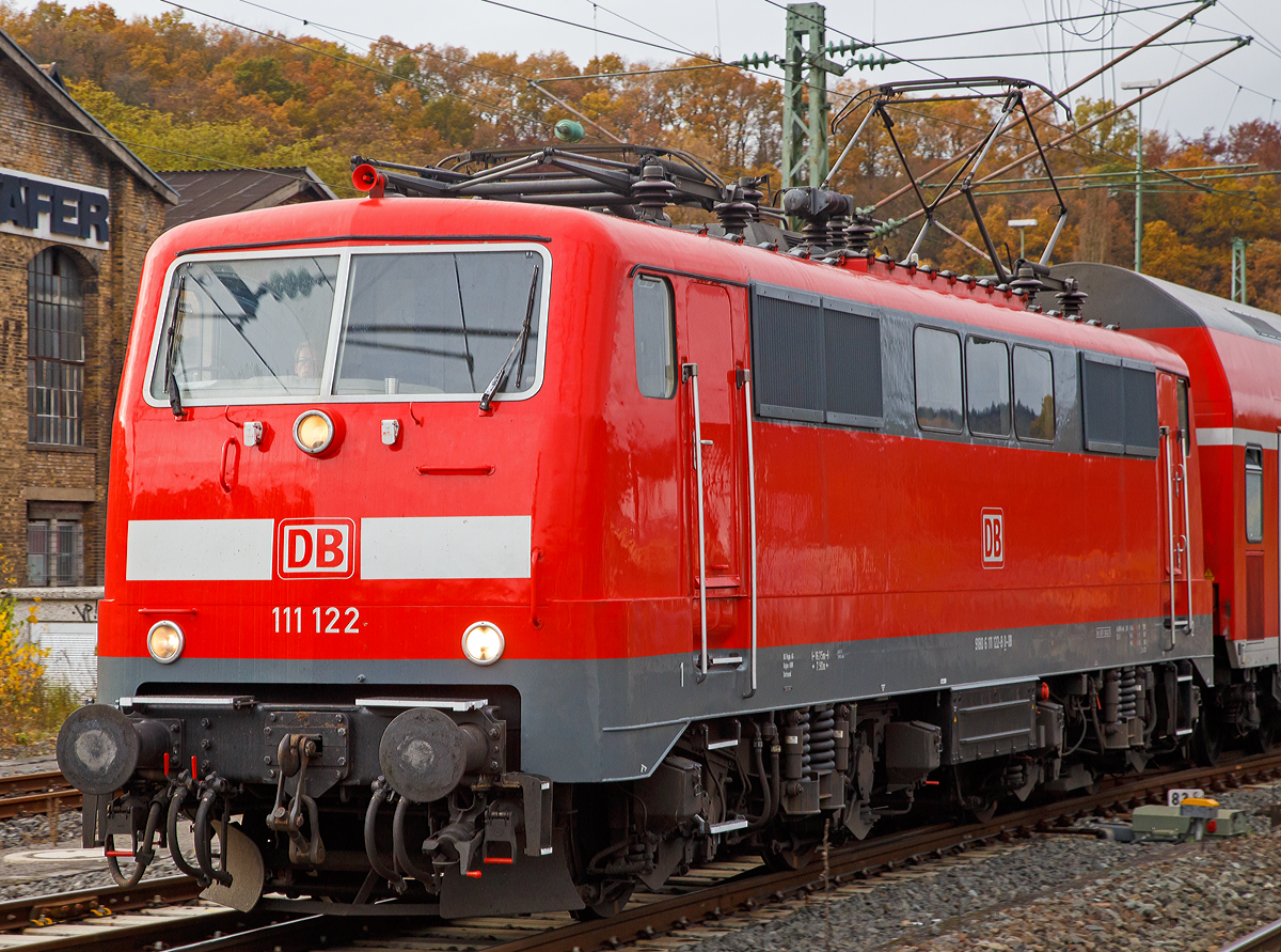 Die 111 122-8 (91 80 6111 122-8 D-DB) der DB Regio NRW fährt am 07.11.2015, mit dem RE 9  rsx / Rhein-Sieg-Express  (Aachen-Köln-Siegen), in den Bahnhof Betzdorf/Sieg ein. 

Die Lok wurde 1980 von Krauss-Maffei in München unter der Fabriknummer  19854 gebaut, der elektrische Teil wurde von Siemens geliefert.

Von den Loks der Baureihe 111 wurden zwischen 1974 bis 1984 insgesamt 227 Stück von verschiedenen Herstellern (AEG, BBC, Henschel, Krauss-Maffei, Krupp, Siemens) gebaut, 222 Stück sind noch im Bestand der DB. Die Baureihe 111 ist die Nachfolgerin der Schnellzuglok-Baureihe 110, an deren Konstruktion sie sich auch stark anlehnt.  Besonderes Augenmerk legte man dabei auf die Verbesserung der Laufruhe bei hohen Geschwindigkeiten durch neue Drehgestelle und verbesserte Arbeitsbedingungen für den Lokführer.

Auf dem Dach waren die neuen Einholm-Stromabnehmer Bauart SBS 65 vorgesehen, welche jedoch bei den Maschinen der ersten bis dritten Serie (111 001–146) nur zum Teil verwendet wurden und kurz darauf wieder abgebaut und gegen Scherenstromabnehmer der Bauart DBS 54 ausgetauscht wurden, da die Einholmstromabnehmer für die Baureihe 103 benötigt wurden. Deshalb fahren Loks der ersten Serien teilweise bis heute mit Scheren-Stromabnehmern DBS 54a, wie hier die gezeigte 111 122-8.

Eingesetzt werden die 160 km/h schnellen Lokomotiven heute vorwiegend im Regional- und Nahverkehr, während bei der Indienststellung auch der leichte Personen-Fernverkehr zu ihrem Aufgabengebiet gehörte.


Technische Daten:
Spurweite: 1.435 mm
Achsformel: Bo'Bo'
Länge über Puffer: 16.750 mm. 
Fahrmotoren: 4 Stück  á 905 kW = 3.620 kW Leistung, 
Dienstgewicht: 83 t 
Anfahrzugkraft: 274 kN
Höchstgeschwindigkeit: 160 km/h