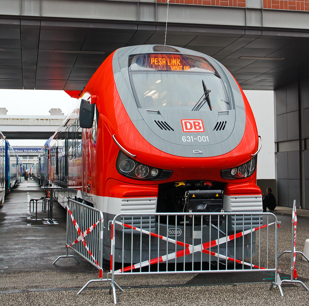 
Die Deutsche Bahn AG und der polnischer Hersteller PESA stellen ersten Dieseltriebzug LINK für die DB vor. Hier das Vorserienfahrzeug 631-001 (95 80 0631 001-4 D-DB ABpd) ausgestellt am 26.09.2014 auf der InnoTrans 2014 in Berlin.

Der PESA LINK (Projektname DMU 120) ist ein Dieseltriebwagen des polnischen Herstellers PESA (Pojazdy Szynowe PESA Bydgoszcz Spolka Akcyjna). Die ČD (Tschechische Bahnen) vermarkten sie als „RegioShark“ (RegioHai), Hai war auch mein erster Eindruck. Es werden verschiedene Varianten von ein- bis vierteiligen Triebzügen angeboten. Diese einteilige Variante ist als Baureihe 631 eingereiht, von denen die DB nur ein Fahrzeug zur Erprobung und zur späteren Reserve bestellt hat. Ansonsten har die Deutsche Bahn AG zurzeit 22 Zweiteiler (BR 632) und 49 Dreiteiler (BR 633) bestellt. Ab Dezember 2015 sollen die ersten planmäßig auf dem Sauerland-Netz (als RB 52 bis 54 und RE 57) fahren.

Der einteilige PESA Link der BR 631 hat einem Dieselmotor (MTU PowerPack) mit einer Leistung von 565 kW, welcher beide Achsen eines Drehgestelles antreibt. Der Motor erfüllt die Stage-IIIb-Abgasnorm und beschleunigt den Triebwagen auf bis zu 140 km/h. Der PESA Link erlaubt Mehrfachtraktionen von drei Treibzügen.

Der Innenraum des Pesa Link ist im Mittelteil in Niederflurbauweise ausgeführt, während die Fahrgastbereiche an den Fahrzeugenden hochflurig ausgelegt sind. Die Bodenhöhe des Niederflurbereichs beträgt in der DB-Version 760 mm, um einen niveaugleichen Übergang von Bahnsteig zu Fahrzeug zu gewährleisten. Jedes Fahrzeug verfügt über ein Mehrzweckabteil Rollstuhlrampen für ältere Bahnsteige von geringerer Höhe und eine behindertengerechte Toilette. In den Fahrzeugen sind Monitore installiert, auf denen sich der weitere Fahrtverlauf nachvollziehen lässt. Die Fahrzeuge der Deutschen Bahn im Sauerland-Netz werden überdies mit einem Fahrkartenautomaten und Steckdosen für die Fahrgäste ausgestattet sein.

Technische Daten der BR 631:
Spurweite: 1.435 mm (Normalspur)
Achsformel: B'2'
Länge über Puffer:  28,65 m
Höhe: 4.280 mm
Breite: 2.880 mm
Achsabstand im Drehgestell: 2.100 mm
Kleinster bef. Halbmesser: 100 m (Werkstatt) / 150 m (Betrieb)
Höchstgeschwindigkeit: 140 km/h
Installierte Leistung: 565 kW 
Beschleunigung:  0,74 m/s²  0-30 km/h
Antrieb: MTU Powerpack
Kupplungstyp: 	Scharfenberg
Sitzplätze: 50
