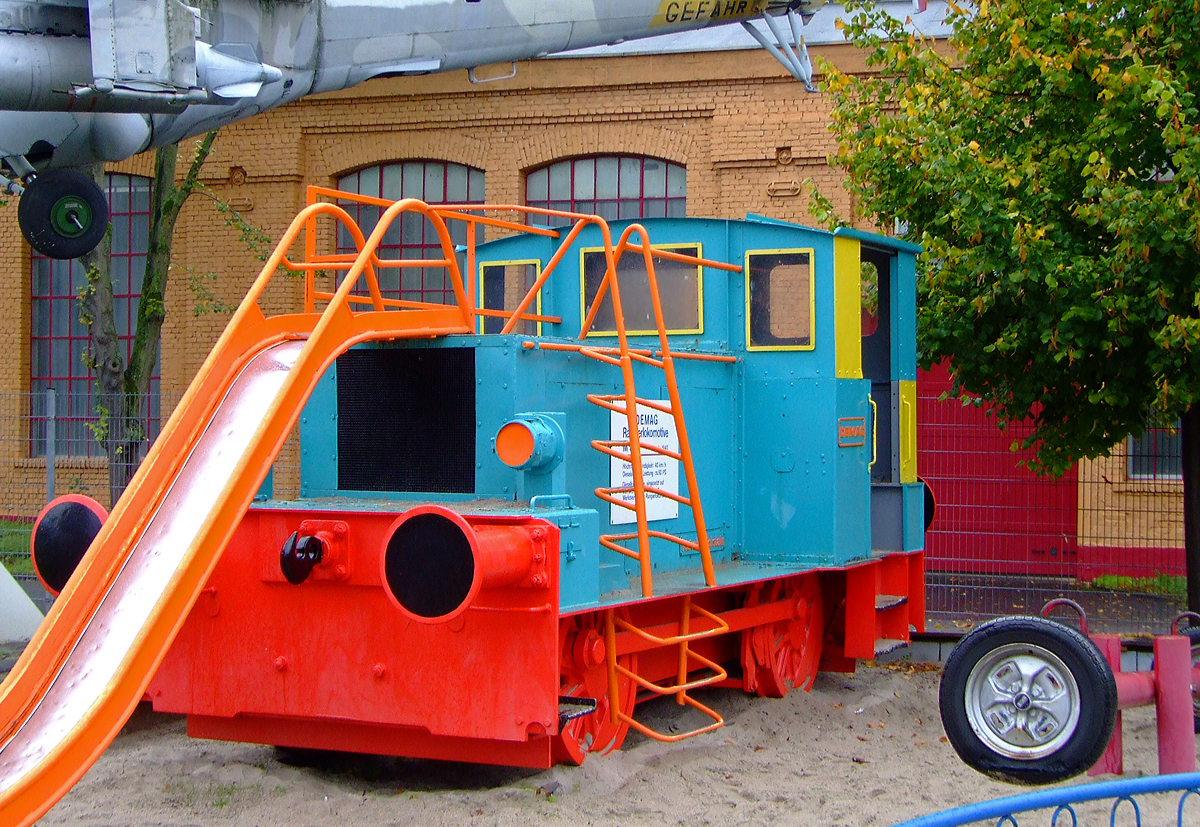 Die ehemalige Lok 22 der Sddeutsche Zucker AG, eine Diesel-Rangierlokomotive vom Typ DEMAG ML 55 am 02.10.2010 im Technik Museum Speyer noch als Spielobjekt. Nachdem sie einige Jahre als Spielobjekt diente, ist sie mittlerweile ein Ausstellungstck auf dem Freigelnde.

Die normalspurige Lok wurde 1940 von DEMAG im Werk Wetter (Ruhr) fr Sdzucker (Werk Zttlingen-Jagst) gebaut (Fabriknummer unbekannt), mit der Schlieung des Werkes 1971 ging sie an einen Schrotthandel, ber diesen kam sie zum ATM - Auto & Technik Museum Sinsheim und 1996 zum Technik Museum Speyer (die Museen Sinsheim und Speyer gehren zusammen). 

Wenig ist ber den Diesellokbau bei der DEMAG im Werk Wetter (Ruhr) bekannt. Der Schwerpunkt lag bei Druckluftlokomotiven fr den Bergbau. 1936 nahm die DEMAG den Dieselllokomotivbau auf. Die Anzahl der gebauten Maschinen bis zur Einstellung des Lokbaus 1957 ist unbekannt. Die Normalspurlokomotiven machen nur einen Bruchteil der Diesellokproduktion aus.

Die Deutsche Maschinenfabrik AG (DEMAG), entstand 1910 durch den Zusammenschluss der Mrkischen Maschinenbau-Anstalt L. Stuckenholz AG, Wetter, der Duisburger Maschinenbau AG, und der Benrather Maschinenfabrik GmbH.

Der ganz berwiegende Teil der normalspurigen DEMAG-Lokomotiven war vom Typ ML 55. 

TECHNISCHE DATEN der ML 55:
Spurweite:  1.435 mm
Achsfolge: B
Lnge ber Puffer:  5.800 mm
Achsstand:  2.500 mm
Raddurchmesser neu:  850 mm
Dienstgewicht:  15t
Motor: MWM  3 Zylinder / 4-Takt-Dieselmotor vom Typ GS 17 D
Leistung:  55 PS bei 1150 U/min
Hchstgeschwindigkeit:  14,5 km/h
