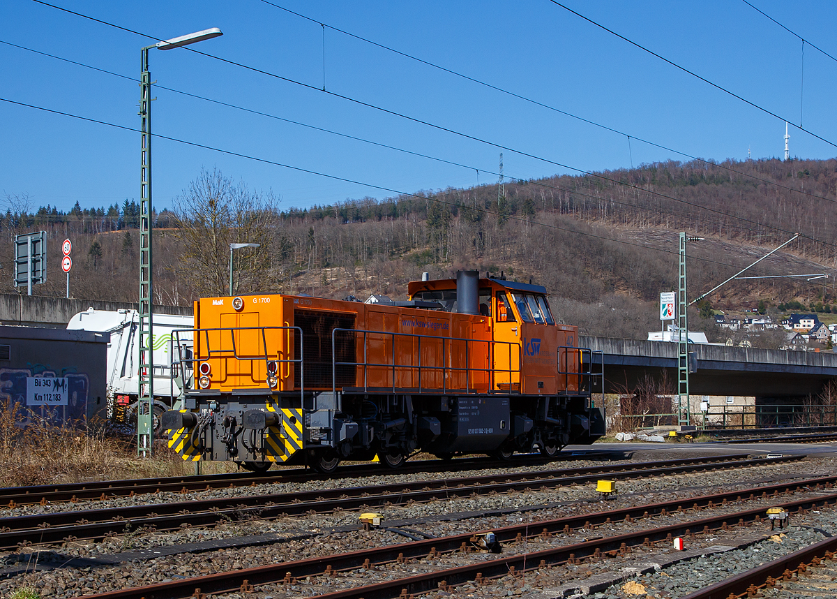 Die KSW 42 bzw. 277 902-3 (92 80 1277 902-3 D-KSW) der KSW (Kreisbahn Siegen-Wittgenstein), fährt am 24.03.2021 als Tfzf (Triebfahrzeugfahrt) bzw. Lz (Lokzug) durch Niederschelden in Richtung Betzdorf (Sieg). Nach dem Umsetzen in Betzdorf fährt sie dann nach Herdorf.

Die Lok ist eine Vossloh MaK G 1700 BB sie wurde 2001 unter der Fabriknummer 1001108 bei Vossloh gebaut, und war die erste gebaute G 1700 BB.

Die Vossloh Lokomotive MaK G 1700 BB ist eine dieselhydraulische Lokomotive. Bei der Überarbeitung der Typenpalette nach der Übernahme der MaK durch Vossloh 1998 wurde im 4. Typenprgramm unter der Bezeichnung G 1700 BB der Bau einer vierachsigen Streckenlokomotive mit Mittelführerhaus vorgesehen. Tatsächlich handelte sich zunächst um eine Weiterentwicklung der G 1206. Die Maschine wurde in einigen Details an die Lokomotiven des 4. Typenprgramms angepasst. Dies betraf in erster Linie den Rahmen, der so geändert wurde, dass die neuen Standarddrehgestelle verwendet werden konnten. Dabei wurden die Rahmenenden so umgestaltet, dass die Lokomotiven die im 4. Typenprgramm üblichen Komfortaufstiege erhielten. Ebenfalls geändert wurde der Dieselmotor. Zum Einsatz kam der schon bei den G 1206 für die Dortmunder Eisenbahn verwendete MTU 12V 4000 R20 mit einer unveränderten Leistung von 1500 kW. Die übrigen Komponenten der G 1700 BB blieben gegenüber der G 1206 weitgehend unverändert.

Die ersten beiden Lokomotiven dieses Typs wurden im Jahr 2001 ausgeliefert. Ende 2002 und Anfang 2003 folgten weitere vier Lokomotiven als Vorratsbauten.

Nach diesen sechs Lokomotiven wurde der Bau der G 1700 BB zugunsten der technisch sehr ähnlichen und bereits weiter verbreiteten G 1206 wieder eingestellt.

Bei der G 1700-2 BB handelt es sich nicht um eine Weiteentwicklung der G 1700 BB, sondern um eine komplette Neuentwicklung. 

Technische Daten
Spurweite:  1.435 mm
Achsfolge:  B´B´  
Länge über Puffer: 14.700 mm 
Drehzapfenabstand:  7.400 mm 
Drehgestellachsstand:  2.400 mm 
größte Breite:  3.080 mm
größte Höhe über Schienenoberkante:  4.220 mm
Raddurchmesser neu: 1.000 mm
kleinster befahrbarer Gleisbogen:  60 m
Dienstgewicht  87,3 t 
Kraftstoffvorrat  3.500 l
             
Motor:  MTU-12-Zylinder-Dieselmotor, vom Typ  12V4000R20 
Leistung:  1.500 kW bei 1800 U/min
             
Getriebe:  Voith L 5r4 zU2 
Höchstgeschwindigkeit : 100 km/h 
             
Baujahr  2001 - 2003 
gebaute Stückzahl  6
