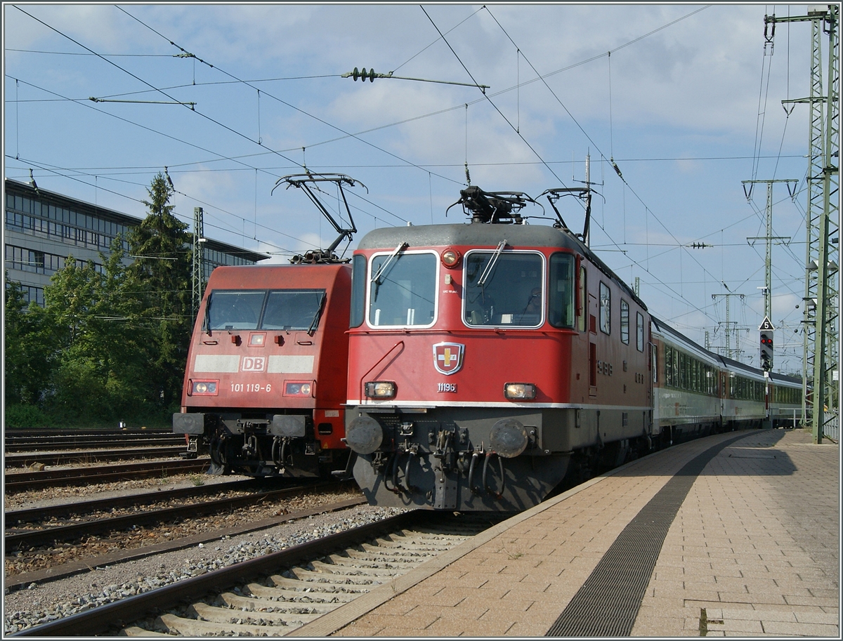 Die Re 4/4 II 11196 erreicht mit ihrem IC 282 von Zürich nach Stuttgart den Bahnhof Singen. Auf dem Nebengleis wartet schon die DB 101 119-6 welche den Zug ab Singen übernehmen wird.
2. August 2015
