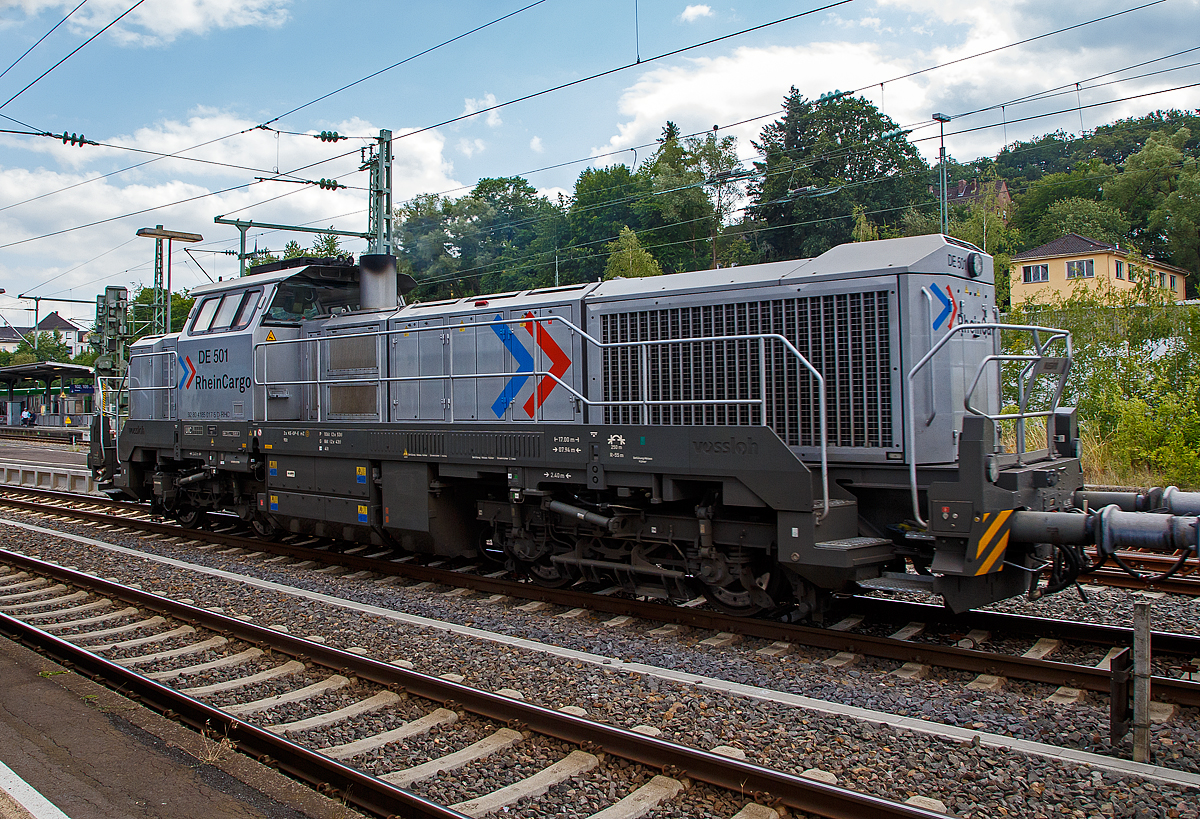 Die RHC DE 501 alias 4185 017-5 (92 80 4185 017-5 D-RHC), eine Vossloh DE 18, der RheinCargo fhrt am Sonntag den 07.07.2019 mit einem Kalkzug (4-achsige Trichtermittenentladewagen der Gattung Tadns) durch Betzdorf/Sieg in Richtung Siegen.

Die dieselelektrische DE 18 wurde 2017 von Vossloh unter der Fabriknummer 5502235 gebaut.

Die Vossloh DE 18 ist eine diesel-elektrisch angetriebene Lokomotive fr den schweren Rangier- und Streckendienst mit der Achsfolge Bo'Bo'. Es handelt sich um die erste Lokomotive aus dem ehemaligen MaK-Werk Kiel seit der Einstellung der Produktion der DE 1002 im Jahr 1993. Etwa 60 % der Bauteile der DE 18 sind mit denjenigen der diesel-hydraulischen Variante G 18 deckungsgleich. Die Konstruktion des Fahrzeuges entspricht nach Herstellerangaben der Crash-Norm EN 15227. Einsatzbereit mit mehreren europischen Lnderzulassungen nach TSI hat sich die vierachsige Universallokomotive als hochmoderner Branchenstandard etabliert. Bei Geschwindigkeiten zwischen 17 und 120 km/h bietet die DE 18 kontinuierlich eine Leistung von 1.800 kW, was sie zur aktuell leistungsstrksten Mittelfhrerhauslokomotive auf dem europischen Markt macht.

TECHNISCHE DATEN:
Spurweite:  1.435 mm 
Achsfolge:  B‘B‘
Lnge ber Puffer : 17.000 mm  
Drehzapfenabstand: 7.940 mm
Achsabstand im Drehgestell: 2.400 mm
Raddurchmesser:  1.000 mm (neu) / 920 mm (abgenutzt)
Grte Hhe:  4.310 mm  
Grte Breite:  3.080 mm
Hchstgeschwindigkeit: 120 km/h
Dieselmotor Typ:  MTU 12V 4000 R43L 
Dieselmotorleistung:  1.800 kW (2.447 PS) bei 1.800 U/min
Leistungsbertragung: elektrisch
Stromrichter : IGBT
Traktionsmotoren: 4 Stck Drehstrom-Asynchronmotoren
Leistung am Rad: 1.440 kW
Anfahrzugkraft:  300 kN
Dauerzugkraft: 230 kN bei 24.2 km/h
Dienstgewicht:  90 t
Kraftstoffvorrat:  4.000 l
Elektrodynamische Bremsleistung: max. 1.450 kW  
Bremse: 2 x KE-GP-E mZ (D)
Kleinster befahrbarer Bogenradius:  55 m

Weitere Motordaten (MTU 12V 4000 R43L):
Dieselmotorart: 12 Zylinder -Viertakt-90-V-Dieselmotor mit Abgasturboaufladung, Ladeluftkhlung und Common-Rail-Einspritzung
Motorhersteller: Motoren- und Turbinen-Union Friedrichshafen (MTU)
Motorhubraum: 57.2 l ( 170 mm Bohrung x 210 mm Hub)
Motorabmessungen: 2.386 x 1.562 x 2.015 mm
Motorgewicht: 6.613 kg (trocken)
Abgasvorschriften:  EU/2004/26 Stufe IIIA/prepared for stage IIIB  
