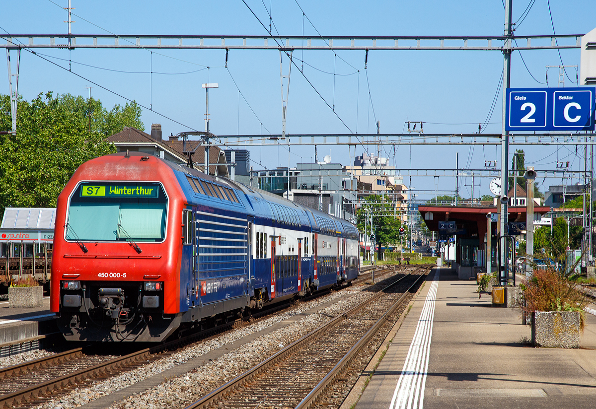 Die SBB Re 450 000-5  Seebach , ex Re 4/4 450 000, schiebt einen Doppelstock-Pendelzug (der erste Generation) Zürcher S-Bahn als S7 nach Winterthur in den Bahnhof Zürich-Tiefenbrunnen. 

Die Lok wurde als Re 4/4 V - 10500 bestellt, bei der Auslieferung 1989 wurde sie aber schon als Re 450 000-5 bezeichnet. Sie war die erste von 115 Stück gebauten Loks.

Aufgrund des Pendelzugbetriebs wurde auf einen zweiten Führerstand verzichtet und der gewonnene Platz für ein Gepäckabteil genutzt. Äußerlich wurden Loks  an den Doppelstock-Pendelzugs (DPZ) angeglichen und mit entferntem zweitem Führerstand erinnert nichts daran, dass die Re 450 technisch weitgehend den ab 1987 von SLM/BBC für Privatbahnen gebauten Re 456 entspricht. Das Fahrwerk ist allerdings eine Neuentwicklung von SIG. Die Re 450 ist die erste Lok in großer Serie von Umrichterlokomotiven mit GTO-Thyristoren und Drehstrom-Asynchronmotoren, welche bei der SBB im Einsatz kamen. 

Zwischen 1989 und 1997 wurden insgesamt 115 Stück der Re 450 von SLM/ABB gebaut. Die erste Serie von 24 Lokomotiven wurde noch unter der Bezeichnung Re 4/4V (10500 – 10523) bestellt, trug bei Auslieferung allerdings bereits die neue Bezeichnung Re 4/4 450 (450 000 – 450 023) unter welcher auch die zweite Serie von 26 Maschinen (450 024 – 450 049) abgeliefert wurde. Zwischenzeitlich änderte die SBB die Baureihen- und Betriebsnummern erneut, und die Lokomotiven erhielten ihre heute noch unverändert gültige Baureihenbezeichnung Re 450. Aufgrund der starken Auslastung der SLM durch den Bau der SBB Re 460, welche 1992 in großem Stil anlieft, wurden die 45 Lokomotivkästen der dritten Serie (450 050 – 450 094) von Schindler Waggon (SWP/SWG) aus dem Werk Pratteln geliefert. Die vierte und letzte Serie von nochmals 20 Maschinen (450 095 – 450 114) wird ab 1996 geliefert – nach Abschluss der Auslieferung der Re 460. Bei diesen Maschinen wurde wieder der Lokkasten von SLM gebaut, während die ABB Verkehrstechnik, inzwischen unter dem Namen Adtranz, erneut die elektrische Ausrüstung liefert.

Die zugehörigen Doppelstockwagen wurden im selben Zeitraum von Schindler Waggon (Wagenkasten, mechanische Teile), SIG (Fahrwerk) und ABB respektive Adtranz (elektrische Ausrüstung) gebaut. Eine Re 450-Pendelzugskomposition besteht generell aus einem AB- und einem B-Wagen sowie einem Steuerwagen (Bt).

Die Re 450 und die zugehörigen DS-Bt verfügen über automatische Kupplungen vom Typ +GF+ Vorortsbahnkupplung (GFV) und werden im Normalbetrieb jeweils kompositionsweise über die automatische Kupplung gekoppelt. Die Vielfachsteuerung erlaubt das gemeinsame Führen von bis zu vier Pendelzugkompositionen. Da die Nutzlänge der Perrons auf dem Zürcher S-Bahn-Netz in der Regel auf maximal 320 m beschränkt ist, wurde die Anzeige- und Diagnoseebene der Führerstände auf nur drei Einheiten ausgelegt.

Im Zuge des Modernisierungsprogrammes „Lion“ werden die Re 450 im Industriewerk Yverdon (zwischen 2011–2018) grundlegend saniert, die 450 000-5 ist noch nicht modernisiert.
 • Folgende Arbeiten werden ausgeführt:
 • Rostsanierung und Neulackierung
 • Ersatz der Fahrmotorrotoren und Neuwicklung der Statoren
 • Ersatz der Getriebekästen
 • Ersatz der Frontbeleuchtung durch LED-Beleuchtung
 • Ertüchtigung der Traktionsstromrichter
 • Ersatz der Geschwindigkeitsmessanlage mit integrierten Sicherheitssystemen und Fahrdatenregistrierung
 • Nachrüstung Druckluftanlage mit Lufttrockner und automatischem Wasser-/Ölabscheider

TECHNISCHE DATEN:
Gebaute Anzahl: 115 (Re 450 000 bis 114)
Spurweite: 	1435 mm (Normalspur)
Achsformel:  Bo'Bo'
Länge über Puffer: 18.400 mm
Höhe:  4.500 mm
Breite:  2.980 mm
Leergewicht:  74 t
Nutzlast (Gepäckanteil):  4 t
Höchstgeschwindigkeit: 130 km/h
Dauerleistung:  3.200 kW
Anfahrzugkraft:  240 kN
Kupplungstyp: GFV (front), Schraubenkupplung (zu den Wagen)
