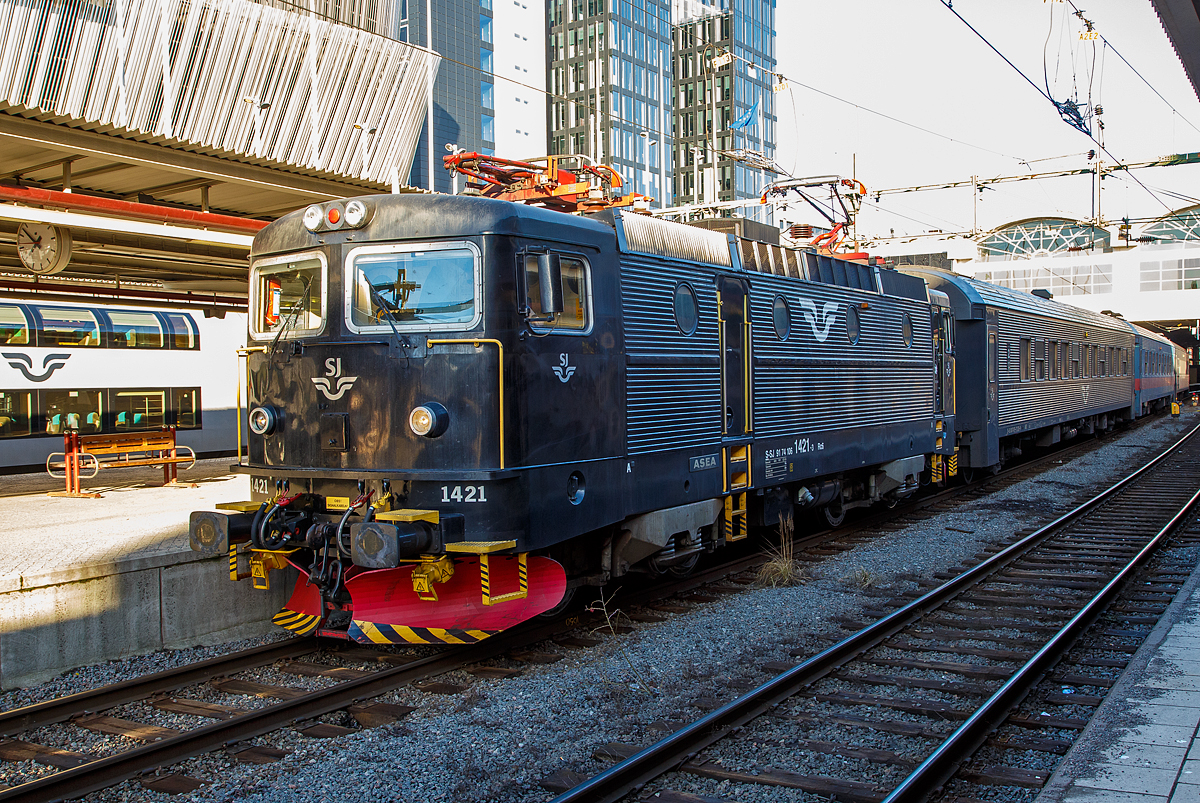 Die SJ Rc6 1421 (S-SJ 91 74 106 1421-3), der schwedische Staatsbahnen Statens Järnvägar, hat am 22.03.2019 mit einem Regionalverkehr Stockholm Central erreicht.

Die Rc 6 wurde 1988 von ASEA (Allmänna Svenska Elektriska Aktiebolaget) in Västerås (Schweden) unter der Fabriknummer 2015 gebaut und an die SJ geliefert. Im Jahr 2001 wurde sie zur Rc7 (auf 180 km/h) umgebaut, aber 2004 wieder auf Rc6 zurückgebaut. ASEA war ein schwedisches Unternehmen, im Februar 1988 legte der Konzern sein Geschäft mit der Schweizer Brown, Boveri & Cie (BBC) zur Asea Brown Boveri (ABB) mit Hauptsitz in Zürich (Schweiz) zusammen.

Die Bauserie Rc6 war die letzte original gebaute schwedischen Rc-Serie. Die 40 Lokomotiven wurden zwischen 1985 und 1988 gebaut und erhielten die Nummer 1383–1422. Wie die Rc3 waren sie ab Werk so ausgelegt, dass ihre Höchstgeschwindigkeit 160 km/h betrug. Zwischen 1992 und 1995 wurden dann auch alle Rc5-Lokomotiven in Rc6 umgebaut, da der Bedarf der SJ an schnellfahrenden Lokomotiven für Reisezüge gestiegen war.

Zwei von den Rc6-Lokomotiven, die 1421 (diese) und die 1422, wurden als Rc7 für 180 km/h umgebaut, um als Lok für Ersatzzüge für die X2000 zu fungieren. Nur die SJ hatte eigentlich keine Reisezugwagen für diese Geschwindigkeit und ein Umbau der Waggons war zu teuer. So wurden die beiden Lokomotiven ein paar Jahre später wieder zurüchgebaut.

TECHNISCHE DATEN der Rc6: 
Hersteller: AESA
Baujahre: 1985 bis 1988
Anzahl: 40 (ursprüngliche Serie)
Spurweite:  1.435 mm (Normalspur)
Achsformel: Bo'Bo'
Länge über Kupplung: 15.520 mm
Drehzapfenabstand: 7.700 mm
Achsabstand im Drehgestell: 2.700 mm
Treibraddurchmesser:  1.300 mm 
Gewicht: 78 t
Höchstgeschwindigkeit: 160 km/h
Leistung: 3.600 kW (4 x 900 kW)
Anfahrzugkraft: 250 kN
Anzahl der Motoren: 4 Stück vom Typ LJM450 á 900 kW
Stromsystem: 15 kV 16 2/3 Hz ~
