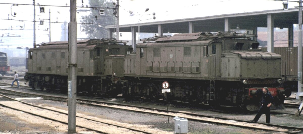 Domodossolo FS E 626 163 und eine E 428, aus fahrendem Zug am 09.09.1980 fotogrphiert.
