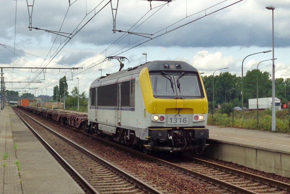 Durch eine leichte Regen und Antwerpen-Luchtbal fahrt am 12 Augustus 2017 NMBS 1316 mit ein Containerzug.
