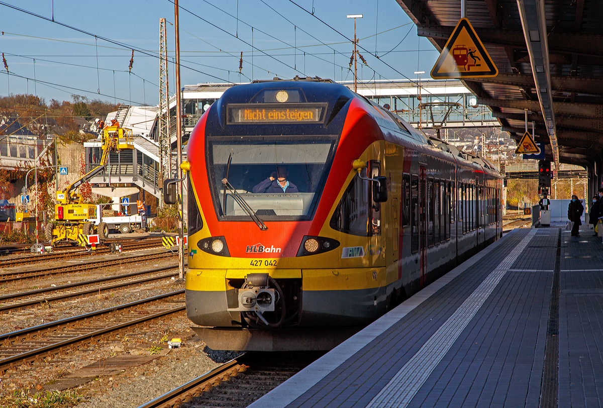 Ein FLIRT im Licht und Schatten....
Der 3-teilige Stadler FLIRT 427 042 / 827 042 / 427 542 (94 80 0427 124-3 D-HEB / 94 80 0827 124-9 D-HEB / 94 80 0427 624-2 D-HEB) der HLB Bahn (Hessischen Landesbahn) hat am 12.11.2021, als RE 99 Gießen – Siegen (Umlauf HLB 24936), den Hauptbahnhof Siegen erreicht.

Der Triebzug wurde 2010 von Stadler Pankow in Berlin unter den Fabriknummern 38623/38624, 38623/38626 und 38623/38625 gebaut und an die HLB geliefert.

Die Bezeichnung „FLIRT“ steht für „Flinker Leichter Innovativer Regional Triebzug“. Seit Dezember 2010 sind für die HLB die dreiteiligen (Baureihe 427) und fünfteiligen (Baureihe 429) elektrischen Niederflurtriebzüge des Typs FLIRT der Firma Stadler Pankow GmbH im „Main-Lahn-Sieg-Netz“ im Einsatz. Die Triebzüge entsprechen höchsten Komfortansprüchen und sind in Aluminium-Leichtbauweise gebaut.

Technische Daten:
Spurweite: 1.435 mm (Normalspur)
Achsformel: Bo'2'2' Bo'
Länge über Scharfenberg-Kupplung: 58.178 mm
Breite:  2.880 mm
Höhe: 4.185 mm
Achsabstände im Drehgestell: 2.700 mm
Triebraddurchmesser: 870/800 mm (neu/abgenutzt)
Laufraddurchmesser: 750/690 mm (neu/abgenutzt)
Dauerleistung am Rad: 1.500 kW
Max. Leistung am Rad: 1.950 kW
Anfahrzugkraft baulich (bis 55 km/h): 150 kN
Max. Beschleunigung bis 80 km/h: 1,01 m/s²
Höchstgeschwindigkeit: 160 km/h
Leergewicht: 100 t
Speisespannung: 15 kV, 16 1/3 Hz
Sitzplätze: 16 (1. Kl.) / 116 (2. Kl.) / 48 Klappsitze
