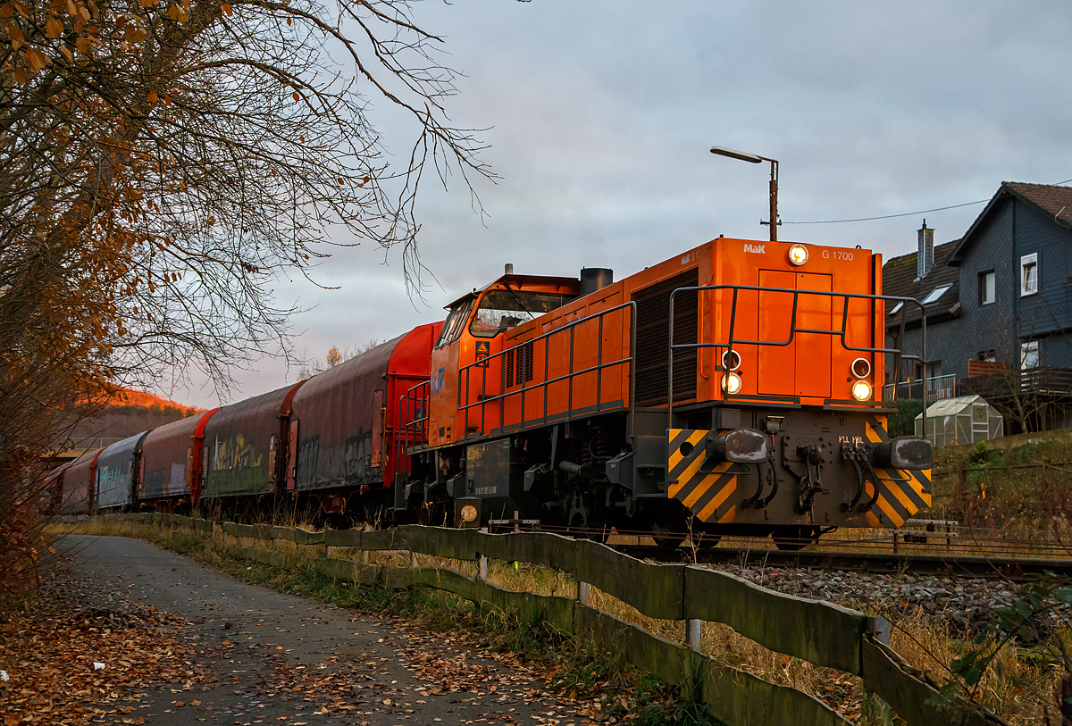 Nun fährt die KSW 42 (92 80 1277 902-3 D-KSW), eine Vossloh MaK G 1700 BB, am spätem Nachmittag des 24.11.2021, mit einem langen Übergabe-Güterzug (von Herdorf zum Rbf Kreuztal), von Herdorf los.