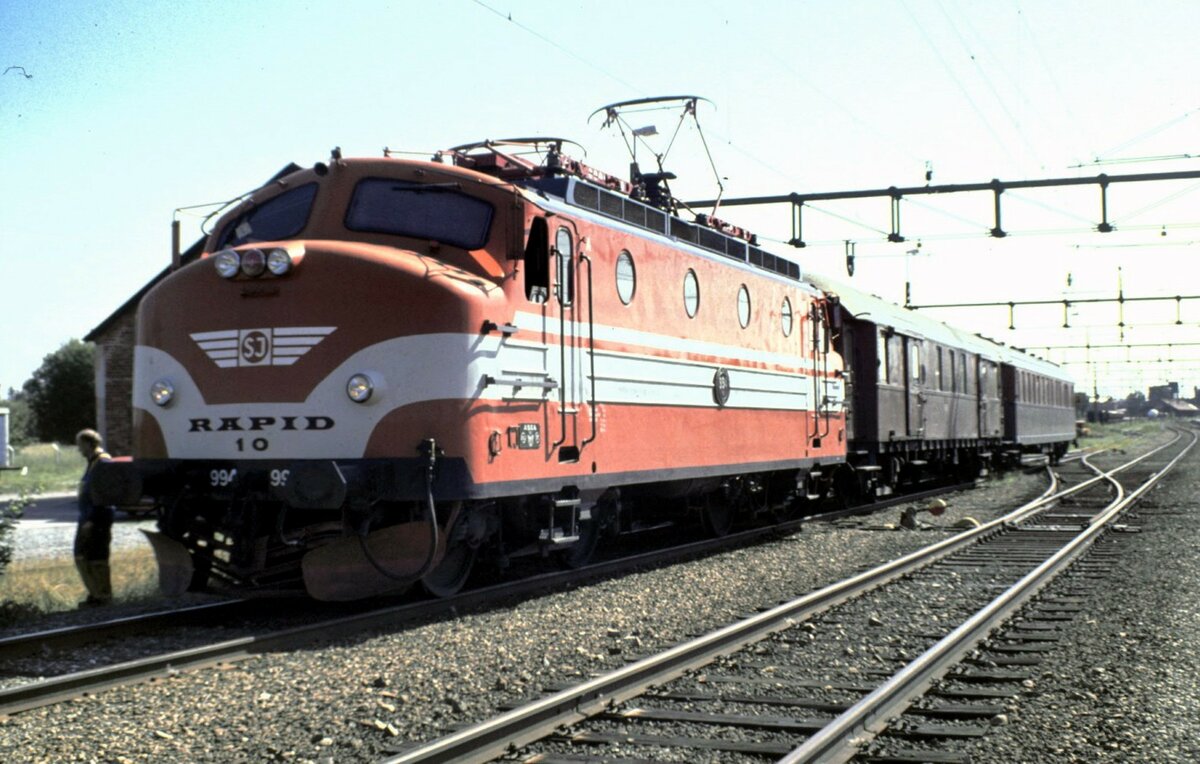SJ Ra Nr.994 Rapid Nr.10 in Sala am 13.08.1994. Der Zug hat in Sala Vorbereitungen zum Abstellen von Dampfloks aus der Kriegsreserve getroffen und wird sich kurz danach auf den Weg machen, die Dampfloks abzuholen.
Die Ra Nr.994 Rapid 10 wurde am 15.06.1961 in Dienst gestellt, hat eine LüP 15100 cm und Vmax 150 km/h. Die Lok gehört dem Stockholm Kultursällskap (SKAJ).