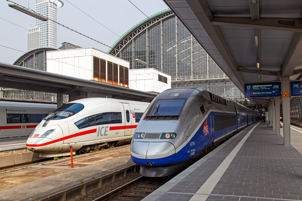 
Unser TGV Euroduplex (2N2) 4714 ist am 24.03.2014 im Hauptbahnhof Frankfurt am Main am Gleis 17, als TGV 9580 / TGV 9581 (Frankfurt am Main Main Hbf - Strasbourg  - Lyon - Marseille St-Charles), bereits bereitgestellt (zuvor fuhr er die Verbindung Paris – Frankfurt). 

Nebenan auf Gleis 18 steht der eingefahrene ICE 3M (Baureihe 406) Tz 4607 „Hannover“, welcher die Zulassungen für Belgien und die Niederlande hat. Auf Gleis 19 steht der ICE 3MF (Baureihe 406F) Tz 4683 „Limburg an der Lahn“, ex Tz 4606, dieser hat die Zulassungen für Frankreich und die Niederlande.