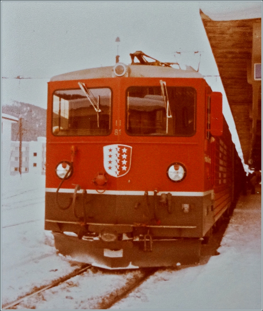Vor dem Einsatz als  Tunnellok  für die Autozüge durch den Furkatunnel hatte die FO keinen Bedarf an den bereits erhaltenen zwei Ge 4/4 III 81 und 82 und so wurden sie bei der RhB eingesetzt. Im Bild die FO Ge 4/4 III 81  Wallis  abfahrbereit mit einem Reisezug nach Landquart in Davos Platz. 

Analog Bild vom Winter 1981/82