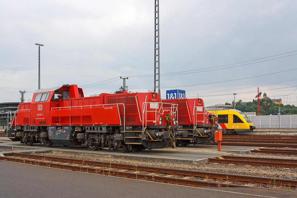 
Zwei Voith Gravita 10 BB, 261 054-1 und dahinter die 261 051-7der DB Schenker Rail abgestellt am 02.08.2014 beim Bahnhof Montabaur. Beide Voith Gravita 10 BB wurden 2011 gebaut, die 261 051-7 unter der Fabriknummer L04-10102 und die 261 054-1 unter der Fabriknummer L04-10105. 

Dahinter fhrt der Vectus VT 206 ABp (95 80 0640 106-0 D-VCT) ein Alstom Coradia LINT 27 nach Siershahn (Westerwald)los, mittlerweile gehrt der VT der HLB, 