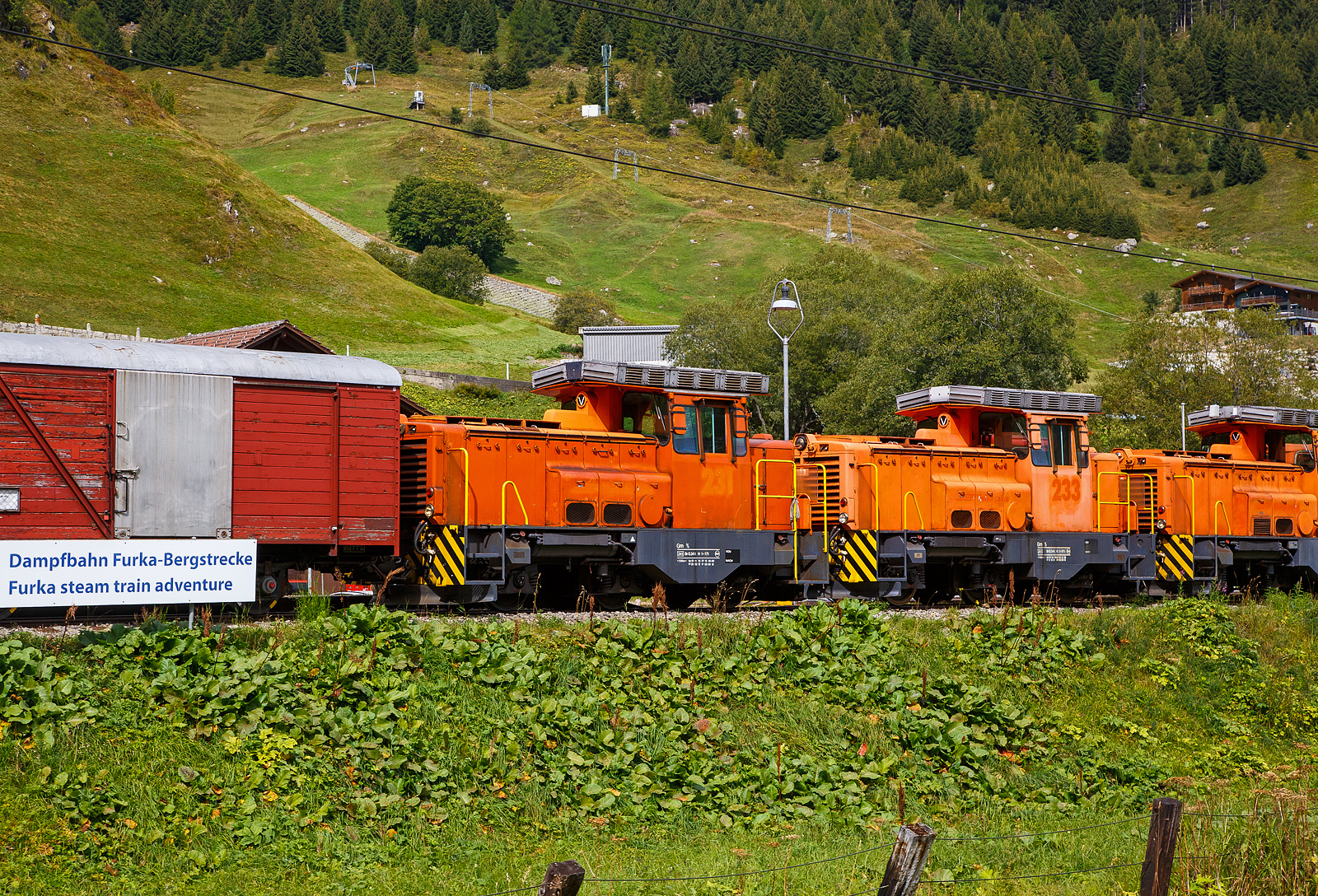 Alle drei ehemaligen dieselelektrische Rangierlokomotive der Rhätischen Bahn - RhB Gm 3/3 – 231bis 233 sind nun bei der - DFB Dampfbahn Furka-Bergstrecke AG. Hier stehen sie aufgereiht noch in der originalen RhB-Lackierung am 07 September 2021 in Realp (Uri) bei der DFB Dampfbahn Furka-Bergstrecke AG, aufgenommen aus einem fahrenden MGB-Zug heraus.

Die Gm 3/3 ist eine dreiachsige dieselelektrische Rangierlokomotive ehemals der Rhätischen Bahn (RhB). Die drei Maschinen mit den Betriebsnummern 231 bis 233 wurden zwischen 1975 und 1976 in Betrieb genommen.

Gemäß der ursprünglichen Idee sollte der Hersteller, die französische Firma Moyse /Locotracteurs Gaston Moyse), die meisten Baugruppen aus der Serienproduktion eines französischen Loktyps übernehmen. Die vielen Sonderwünsche der RhB – MTU-Dieselmotor, Vakuumbremse, Vielfachsteuerung, Führerstandseinrichtung nach RhB-Norm, erzwangen jedoch umfangreiche Änderungen und verzögerten die Lieferung der Anfang 1974 bestellten Fahrzeuge erheblich. Typenbezeichnung Moyse ist Type CF 33 EPA 500 MTL, die RhB 231 wurde 1975 unter der Fabriknummer 3553 gebaut, 1976 folgten die RhB 232 unter der Fabriknummer 3554 und die RhB 232 unter der Fabriknummer 3555.

Die Stundenleistung der maximal 55 km/h schnellen und 34 t schweren Lokomotiven beträgt 220 kW am Rad. Der Antrieb erfolgt durch einen MTU V 6-Zylinder-Dieselmotor (MTU 6 V 331 TC10) mit 386 kW (525 PS) Leistung, dieser treibt den Hauptgenerator an, welcher den elektrischen Gleichstrom-Fahrmotor elektrischen. Das Drehmoment wird vom Fahrmotor auf das nachgeschaltete Getriebe übertragen, hier kann zwischen Rangier- und Streckengang gewechselt werden. Die 3 Radsätze werden mittels Kardanwellen vom Getriebe auf die Achsgetriebe angetrieben.

Haupteinsatzgebiet dieser diesel-elektrischen Adhäsionslokomotiven bei der RhB war der Rangierdienst in Landquart, Chur und Untervaz. Dank ihrer hohen Anfahrzugkraft (im Rangiergang 153 kN) und der möglichen Doppeltraktion eigneten sich die robusten Fahrzeuge auch für den schweren Bauzugdienst. Schneeräumfahrten, gemeinsam mit der kleinen Schneeschleuder Xrotm 9216 oder der großen Xrotmt 9217, gehörten ebenfalls zum Einsatzprogramm bei der RhB. Ab Herbst 2020 wurden die drei Loks nur noch als Reserve vorgehalten, im Februar 2021 wurden sie aus dem Betrieb genommen und stillgelegt. Mitte April 2021 wurden alle drei Lokomotiven dann an die Dampfbahn Furka Bergstrecke verkauft.

Bei der DFB:
Für den schweren Rangierdienst in Realp sowie für Baulogistikfahrten im Furka-Scheiteltunnel ist die DFB auf eine leistungsfähige und zuverlässige Adhäsions-Diesellok angewiesen. Bis dahin wurde dafür die von Jung gebaute Gm 4/4 71  Elch  eingesetzt. Seit der Übernahme dieser Lok von der Matterhorn Gotthard Bahn (MGB) im Jahr 2014 hat dieses Fahrzeug den ordnungsgemäßen Unterhalt erfahren. Im Winter 2021/2022 wurde jedoch an dieser inzwischen 55-jährigen Lok eine aufwendige Totalrevision nötig.

Gleichzeitig wurde bekannt, dass die Rhätische Bahn (RhB) ihre drei Gm 3/3 231 bis 233  Moyse  durch Neufahrzeuge ersetzt, so wurde seitens der DFB Ende 2018 das Interesse an diesen Lokomotiven bekundet. Anlässlich der Verhandlungen im ersten Quartal 2021 wurden der DFB AG zwei Lokomotiven zugesagt. Als der dritten Lok die Verschrottung drohte, ergab sich für die DFB die Gelegenheit, auch diese zwecks erweiterter Ersatzteilhaltung zu übernehmen. Die Überführung (ob aus eigener Kraft ist mir unklar) der drei Gm 3/3 durch die RhB von Landquart nach Disentis/Mustér erfolgt am frühen Morgen des 12. April 2021. Am Tag darauf wurden die drei  Moyse  einzeln durch die MGB, jeweils in einen MGB-Personenzug direkt hinter einer HGe 4/4 II (gemischte  Zahnrad- und Adhäsionslokomotive) eingestellt. Die RhB Gm 3/3sind ja reine Adhäsionsloks, zwischen Disentis und Andermatt bzw. Realp gibt es ja Zahnstangeabschnitte mit bis zu 120 ‰ Neigung.

Danach ging die Dieselcrew der DFB an die Bereitstellung der ersten Gm 3/3. Am 28. Dezember 2021 konnte die Gm 231 für den Betrieb freigegeben werden. An diesem Tag und an den beiden nachfolgenden Tagen wurden theoretische und praktische Fahrzeugschulungen durchgeführt. Aktuell sind acht Lokführer auf den Gm 3/3 instruiert, weitere Schulungen werden folgen.

Danach galt es, Erfahrungen im Schneeräumeinsatz im Bahnhof Realp mit der Xrotm 9216  Schleuderina  zu sammeln. Die Gm 231 kommt außerdem für schwere Rangiermanöver zum Einsatz. Inzwischen hatten auch die Arbeiten zur Wiederinbetriebnahme der Gm 233 begonnen. Mit zwei betriebsbereiten Loks wird die Dieselcrew die Traktionsbedürfnisse auf den Adhäsionsabschnitten ohne Zahnstange flexibel abdecken können. Die Gm 232 bleibt bis auf weiteres außer Betrieb.

Status der Gm 3/3: 
Lok 231 und 233: in Betrieb
Lok 232 abgestellt (Reserve/Ersatzteilspender) 
Die UIC-Fahrzeugnummern sind 90 85 822 0231-7, 0232-5 und 0233-3.

TECHNISCHE DATEN:
Spurweite: 	1.000 mm (Meterspur)
Achsformel: C
Länge über Puffer: 7.960 mm
Achsabstände: 1.935 mm / 2.265 mm = 4.200 mm
Breite: 2.700 mm
Höhe: 3.560 mm
Dienstgewicht: 34 t
Höchstgeschwindigkeit:  55 km/h (35 km/h im Rangiergang)
Dauerleistung Dieselmotor: 386 kW (525 PS), 
Motordrehzahl: max. 2.000 U/min
Dauerleistung am Rad: 220 kW (300 PS)
Anfahrzugkraft: 153 kN (Rangiergang) / 61 kN (Streckengang)
Stundenzugkraft: 83.4 kN (Rangiergang) / 34.3 kN (Streckengang)
Treibraddurchmesser: 	920 mm (neu)
Motor: MTU V 6-Zylinder-Dieselmotor vom Typ 6V 33 1 TC10 
Antrieb: Dieselelektrisch (Drehmomentübertagung siehe Text)
Anhängelast:  35-500 t im Streckengang je nach Neigung (nur Adhäsion)
Bremssysteme: Handbremse, direkte Druckluftbremse (Rangierbremse), druckluftgesteuerte Vakuumbremse (automatische Bremse), elektrische Bremse (Widerstandsbremse)
Sicherheitssysteme: Sicherheitssteuerung (Totmann und Wachsamkeit), Zugsicherung ZSI 90, Geschwindigkeitsmesser mit Fahrtenschreiber (Farbscheibe)

Quellen: DFB Dampfbahn Furka-Bergstrecke AG, bahnonline.ch/, de.wikipedia.org/ und hellertal.startbilder.de
