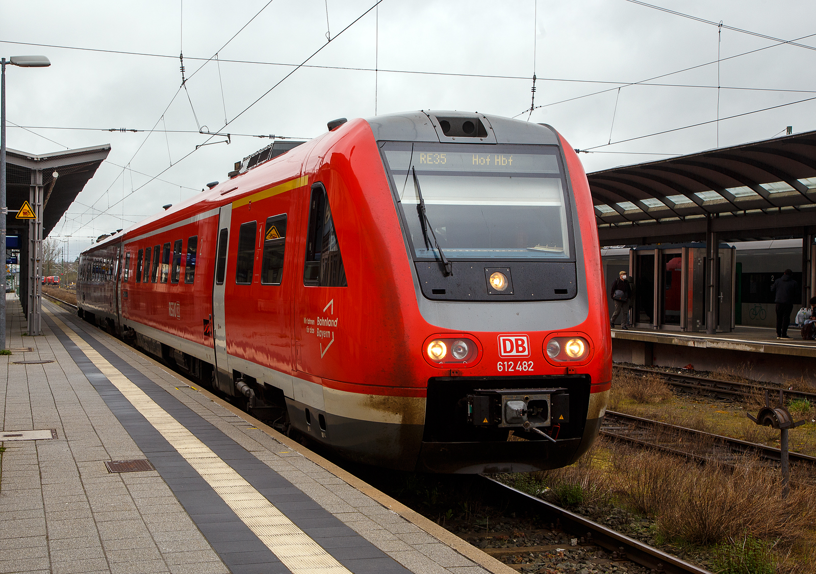 Der Dieseltriebwagen mit Neigetechnik 612 482 / 612 982 (95 80 0612 482-9 D-DB / 95 80 0612 982-8 D-DB), ein Bombardier  RegioSwinger  der DB Regio Bayern, hat als RE 35 „Main-Saale-Express“ (Bamberg – Lichtenfels –Hof), am 17.04.2023 seinen Zielbahnhof Hof erreicht.

Der Triebzug wurde 2003 von Bombardier unter den Fabriknummer 24173 und 24174 gebaut.

Die Fahrzeuge der Baureihe 612 sind Neigetechnik-Nahverkehrsdieseltriebwagen der Deutschen Bahn. Die Fahrzeuge werden vor allem als Regional-Express und Interregio-Express auf bogenreichen Strecken eingesetzt. Der Hersteller Bombardier Transportation bezeichnet die Fahrzeuge als RegioSwinger.

Der VT 612 ist ein zweiteiliger Dieseltriebzug mit Neigetechnik und dieselhydraulischen Antrieb. Die Neigetechnik erlaubt das bogenschnelle fahren. Durch das bogenschnelle fahren kann die Geschwindigkeit im Vergleich zu „herkmmlichen“ Schienenfahrzeugen in kurvenreichen Strecken wesentlich erhht werden, da sich das Fahrzeug bis zu 8 Grad neigen kann. hnlich wie ein serpentinenpassierender Motorradfahrer durchfhrt der Zug die Kurve, was erhebliche Fahrzeitverkrzung mglich macht. Voraussetzung hierfr ist jedoch nicht nur die Fahrzeugtechnik, sondern auch umfangreiche technische Anpassungen an den Gleis- und Signalanlagen entlang der Strecke und den Bahnhfen.

Nach den problembehafteten Triebwagen der Reihe 611 unternahm die Deutsche Bahn mit der fast komplett neu konstruierten Baureihe 612 einen zweiten Versuch, einen zuverlssigen Neigetechnik-Zug aus deutscher Produktion auf die Schiene zu bringen.

Wie bei ihren Vorgngern sind bei der Baureihe 612 beide Wagen motorisiert. Verwendet werden dabei 19-Liter-Cummins- Sechszylinder-Reihenmotor-Dieselmotoren des Typs QSK19-R mit je 563 kW Leistung, die eine Geschwindigkeit von 160 km/h ermglicht. Die Kraftbertragung erfolgt hydraulisch ber je ein Strmungsgetriebe, in das auerdem eine hydrodynamische Bremse integriert ist. Die Triebdrehgestelle liegen bei beiden Wagen einer Einheit am Kurzkuppelende, die Drehgestelle unter den Fhrerstnden sind Laufdrehgestelle. Der Wagenkasten sttzt sich ber Luftfedern und eine Wiege auf den Drehgestellen ab und ist elektrisch 8 zu jeder Seite neigbar. Die Steuerung der Neigetechnik bernimmt das System Neicontrol-E, das ber Beschleunigungssensoren in den Enddrehgestellen Beginn und Ende eines Bogens feststellen kann und den Wagenkasten abhngig von Bogenradius und Fahrgeschwindigkeit neigt. Dies erlaubt gegenber Fahrzeugen ohne Neigetechnik eine Geschwindigkeitssteigerung um bis zu 30 %, sofern die befahrene Strecke sicherungs- und oberbautechnisch fr das bogenschnelle Fahren ausgebaut ist. Zustzlich zu den Betriebsbremsen besitzen die Triebwagen Federspeicherbremsen als Feststellbremsen und fr Schnellbremsungen Magnetschienenbremsen in den Laufdrehgestellen.

ber die selbstttigen Scharfenberg-Kupplungen an den Fhrerstandsenden lassen sich bis zu vier Doppeltriebwagen kuppeln und vielfachsteuern. Die Scharfenberg-Kupplungen verbinden die Druckluft- und Steuerleitungen selbstttig mit. Die Bordrechner der Triebzge stellen automatisch die Zugkonfiguration fest. Fr die Aufrechterhaltung gewisser Grundfunktionen wie Beleuchtung und Heizung ist jeder Triebwagen selbst verantwortlich. Es kann nicht in grerem Umfang elektrische Energie zwischen den Wageneinheiten ausgetauscht werden. ber die Vielfachsteuerung gelangen Zustands- und Strungsmeldungen zum aktiven Fhrerstand.

TECHNISCHE DATEN:
Spurweite: 1.435 mm (Normalspur)
Achsformel: 2’B’+ B’2’
Lnge ber Kupplung (Scharfenberg): 51.750 mm
Achsabstand im Drehgestell: 2.450 mm
Hhe: 4.124 mm
Breite: 2.852 mm
Treibrad- und Laufraddurchmesser: 890 mm
Eigengewicht: 93 t
Dienstgewicht: 116 t
Motorleistung: 2x 560 kW
Hchstgeschwindigkeit: 160 km/h
Sitzpltze: 146
Fubodenhhe: 1.290 mm