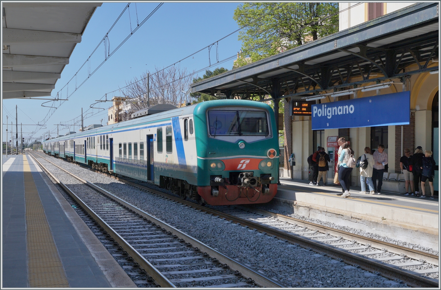 Der FS Trenitalia Regionalzug 4413 von Bari nach Lecce erreicht Polignano A Mare. Trotz der vielen neuen Fahrzeuge sind hin und wieder weiterhin lter Zge im Einsatz, wo wie dieser FS Tpy 73 Niederflurzug (Carrozza vicinale a piano ribassato) in XMPR Lackierung mit einem npBD an der Spitze und vier nB Wagen sowie der schiebenden FS Trenitalia E 464 123. 

22. April 2023