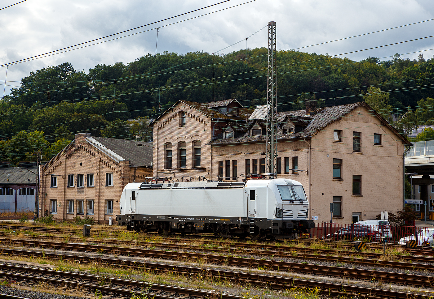 Die an die SETG - Salzburger Eisenbahn TransportLogistik GmbH vermietete weiße SIEMENS Vectron AC DPM 193 919 (91 80 6193 919-8 D-ELOC) der ELL - European Locomotive Leasing ist am 28.08.2023 beim Hbf Siegen abgestellt.

Die SIEMENS Vectron AC DPM mit Diesel Power Modul  bzw. mit LM (Last Mile Diesel) wurde 2022 von Siemens Mobilitiy in München-Allach unter der Fabriknummer 22968 gebaut. Diese Vectron Lokomotive ist als AC DPM – Lokomotive (Wechselstrom-Variante mit Dieselmodul für Rangieren ohne Fahrdraht) mit 6.400 kW konzipiert und zugelassen für Deutschland, Österreich, Bulgarien, Slowakei, Rumänien, Tschechien und Ungarn (D/A/BG/SK/RO/CZ/H), im Dieselbetrieb beträgt die Leistung lediglich 180 kW (160 kW am Rad). 

Diese topmodernen Lokomotiven weisen eine Leistung von 6.400 kW (8.700 PS) auf. Das eingebaute Diesel-Power-Modul ermöglicht das Rangieren ohne Fahrdraht. Zusätzlich sind die Vectron-Lokomotiven von Siemens mit einer Funkfernsteuerung und einer halbautomatischen Bremsprobe ausgerüstet. 

Die Entwicklung der Siemens Lokomotive Vectron basiert auf den Erfahrungen der erfolgreichen EuroSprinter beziehungsweise deren Weiterentwicklung Siemens ES 2007 (NMBS/SNCB-Reihe 18/19) ersetzt. Ausgereifte und bewährte Technik ist mit Flexibilität und Modularität kombiniert. Die Vectron Lokomotive ist für die vielfältigsten Verkehrsaufgaben konzipiert. Ob im nationalen oder grenzüberschreitenden Verkehr, ob im Personen- oder Güterverkehr. Es werden vier elektrische Versionen und eine dieselelektrische Version der Lokomotivplattform angeboten. Die hier gezeigten Vectron Lokomotiven sind als AC – Lokomotiven (Wechselstromlok) mit 6.400 kW Leistung) konzipiert und haben ein Diesel Power Modules (DPM) / Rangiermodul bzw. Last Mile (LM).

Die äußere Gestaltung der Vectron-Lokomotiven unterscheidet sich nur wenig von der der Siemens ES 2007; insbesondere wird das der Crashnorm entsprechende Kopfmodul bis auf einige Detailänderungen, etwa Rückblickkamera statt Seitenfenster, übernommen. Innen ist der neue Typ hingegen komplett anders aufgebaut. Der Maschinenraum besitzt im Gegensatz zur Bombardier TRAXX einen geraden Mittelgang, an dessen Seiten alle Komponenten einen festen Platz haben. In einem unter dem Boden verlaufenden Kanal verlaufen die Steuerleitungen und Druckluftrohre. Die Radsätze werden über gefederte Ritzel-Hohlwellen angetrieben.

Der Vectron unterstützt mit einer optimierten Systemauslegung und vielfältigen Funktionen für energieoptimales Abstellen. Der elektrische Vectron ermöglicht eine erhöhte elektrische Bremskraft von 240 kN. Die rückgewonnene Energie wird hocheffizient für die Versorgung von Hilfsbetrieben genutzt bzw. und wo möglich ins Netz zurückgespeist.

TECHNISCHE DATEN der Vectron AC DPM:
Spurweite: 1.435 mm
Achsformel: Bo'Bo'
Länge über Puffer: 18.980 mm
Drehzapfenabstand: 9.500 mm
Achsabstand im Drehgestell: 3.000 mm
Breite: 3.012 mm
Höhe: 4.248 mm
Raddurchmesser : 1.250 mm (neu) / 1.160 mm (abgenutzt)
Gewicht: 90 t
Spannungssysteme: 15 kV, 16,7 Hz AC (Wechselstrom)
Max. Leistung am Rad: 6.400 kW
Leistungsfaktor: nahe 1
Höchstgeschwindigkeit: 160 km/h
Anfahrzugskraft: 300 kN
Dauerzugkraft: 250 kN
Elektrische Bremskraft: 240 kN
Kraftübertragung: Ritzelhohlwellenantrieb
Lichtraumprofil: UIC 505-1

Leistungsdaten DPM (Diesel Power Modul):
Max. Geschwindigkeit : 40 km/h
Leistung: 180 kW (160 kW am Rad)
Tankvolumen der DPM:  350 l (Diesel)
