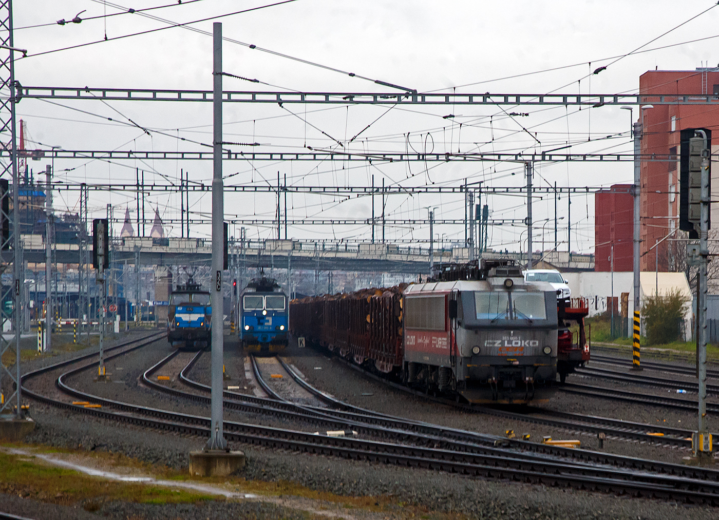 Die an die ungarische CER Cargo vermietet  CZ Loko 365 004-1 (CZ-CZL 91 54 7 365 004-1), eine CZ Loko „Effiliner 3000“, ex SNCB HLE 12, steht am 24.11.2022 bei Pilsen (Plzeň) mit einem Stammholzzug (aufgenommen aus einem alex-Zug).

Und links stehen noch die ČD Cargo 363 503-9 (CZ ČDC 91 54 7 363 505-9) mit einem Gterzug und die elektrische Rangierlokomotive ČD 210 021-2 (CZ ČD 91 54 7 210 021-2) mit einem Personenzug.

