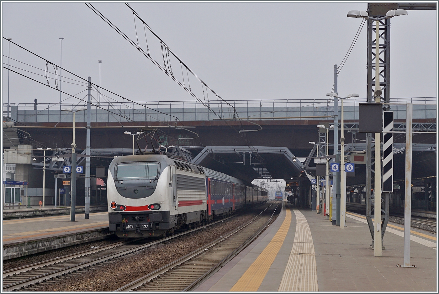 Die FS Trenitala E 402 120 und am Schluss des Zuges die 402 127 sind mit dem Treno di notte ICN 798 von Salerno nach Torino unterwegs. Der Zug erreicht den Bahnhof Rho Fiera Milano wo der ohne Halt durch fährt.

24. Februar 2023