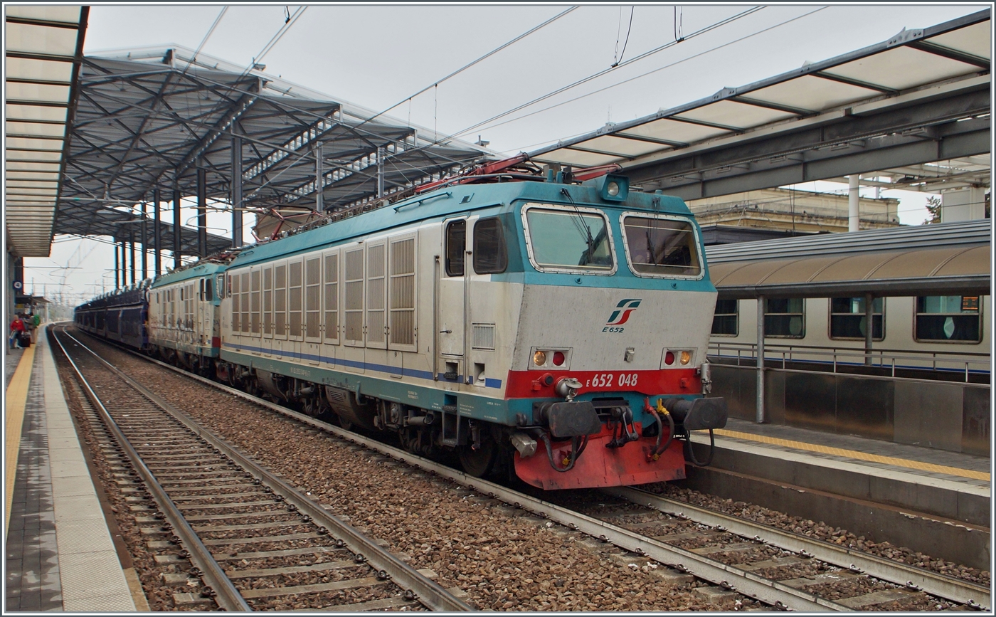 Die FS Trenitalia E 652 048 und eine weitere fahren mit einem Autoverladewagenzug durch den Bahnhof von Parma in Richtung Süden.

20. September 2014