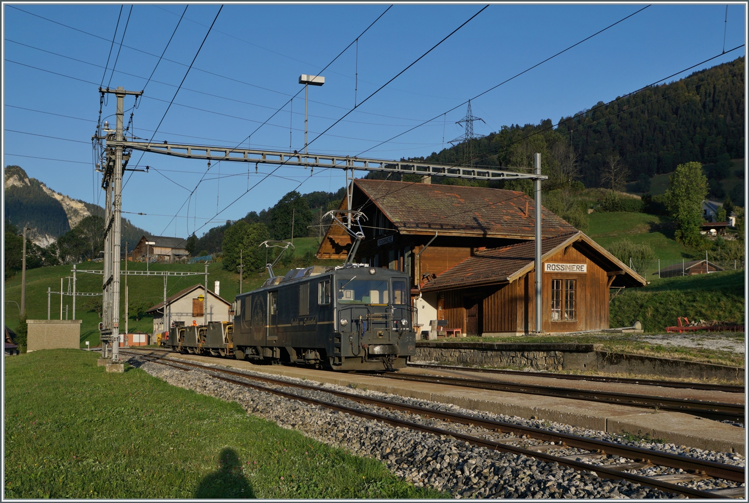 Die GDe 4/4 6002 steht in Rossinière mit einem kurzen Güterzug. Die Lok schob die Wagen und wartet nun auf den Gegenzug. 

29. September 2023