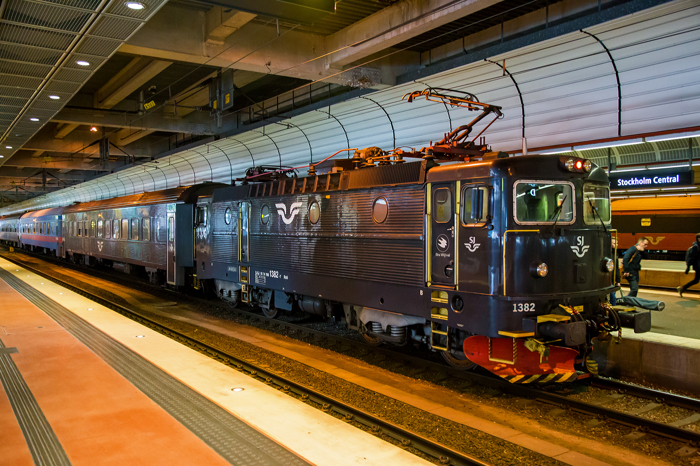 Die SJ Rc6U 1382 (S-SJ 91 74 1061 382-7), ex SJ Rc5 1382, der SJ - Statens Järnvägar AB (ehemalige Schwedischen Staatsbahnen) hat am 21 März 2019 mit einem Personenzug Stockholm Central (Stockholm Hbf) erreicht.

Die fünfte Serie (der Rc-Loks) wurde von 1982 bis 1986 in 60 Exemplaren geliefert. Sie erhielten die Nummern 1323–1388. Wie die Rc1, die Rc2 und die Rc4 erreichten sie eine Höchstgeschwindigkeit von 135 km/h. Sie wurden in ganz Schweden im Reise- und Güterzugdienst eingesetzt.

Von der Rc4 zur Rc5 gab es einen Entwicklungssprung. Die Maschinen erhielten nach neuesten ergonomischen Erkenntnissen ausgestattete Führerstände mit Klimaanlage. Für die Verglasung der Frontfenster wurde Panzerglas verwendet. Es kam eine modernere Version der Thyristor-Stromrichter sowie der Fahrmotoren zum Einsatz. Darüber hinaus wurden die Loks mit einer elektronischen Überwachung, einem Fahrzeugcomputer, ausgerüstet, der Störungen zur Vorbereitung des nächsten Werkstattaufenthaltes in den Führerstand meldet. Optisch unterscheiden sie sich von den früheren Serien durch größere Lufteinlässe, die sich seitlich über die gesamte Dachkante hinziehen.

Danach folgten zwischen 1985 und 1988 gebauten 40 Lokomotiven der Bauserie Rc6 mit den Nummern 1383–1422, dieses war auch die letzte original gebaute Serie. Wie die Rc3 waren diese ab Werk für eine Höchstgeschwindigkeit 160 km/h ausgelegt. Der steigende Bedarf der SJ an schnellfahrenden Lokomotiven für Reisezüge mit einer Höchstgeschwindigkeit von 160 km/h führte dann dazu, dass zwischen 1992 und 1995 alle 60 Rc5-Lokomotiven in Rc6 umgebaut wurden. Sie behielten aber ihre Nummern 1323 bis 1388, so besaß die SJ dann 100 Loks der Baureihe Rc6 (aber keine Rc5 mehr).

SJ Rc6U
Die Rc6 1348–1382 (ex Rc5-Loks) wurden mit SMS-Ausrüstung (schwedisch seriell multipelstyrning) versehen und intern mit der Baureihenbezeichnung Rc6U versehen. Dies wurde an den Fahrzeugen nicht angeschrieben, wird jedoch so im Fahrzeugplanungssystem, in den Fahrzeuglisten und den Werkstattsystemen so verwendet. Diese Technik ermöglicht eine Vielfachsteuerung der Lokomotiven über UIC-Kabel. Sie wurde erstmals verwendet, als SJ drei Steuerwagen der Baureihe AFM7 für den Verkehr zwischen Stockholm und Uppsala beschafften. Die SMS-Ausrüstung war erforderlich, um die Lokomotive vom Steuerwagen aus bedienen zu können. Heute wird sie dort verwendet, wo Züge mit je einer Lok an jedem Ende bespannt werden, wie im Mälardalen, um kurze Wendezeiten der Züge zu erreichen.

Die SJ Rc6U 1382 (diese hier) wurde 1985 von ASEA (Allmänna Svenska Elektriska Aktiebolaget) in Stockholm unter der Fabriknummer 1976 gebaut und an die SJ geliefert. Im Jahr 1993 wurde sie zur Rc6 umgebaut. 

TECHNISCHE DATEN der Rc6:
Hersteller: AESA (heute ABB)
Nummerierung: 1323 bis 1382 (ex Rc 5) und 1383 bis 1422 
Baujahre: 1985 bis 1988(ursprüngliche Serie) und 1982-1986 (ex Rc 5)
Anzahl: 40 (ursprüngliche Serie) und 60 (ex Rc5)
Spurweite: 1.435 mm (Normalspur)
Achsformel: Bo'Bo'
Länge über Kupplung: 15.520 mm
Drehzapfenabstand: 7.700 mm
Achsabstand im Drehgestell: 2.700 mm
Treibraddurchmesser: 1.300 mm
Gewicht: 78 t
Höchstgeschwindigkeit: 160 km/h
Leistung: 3.600 kW (4 x 900 kW)
Anfahrzugkraft: 250 kN
Anzahl der Motoren: 4 Stück vom Typ LJM450 á 900 kW
Stromsystem: 15 kV 16 2/3 Hz ~