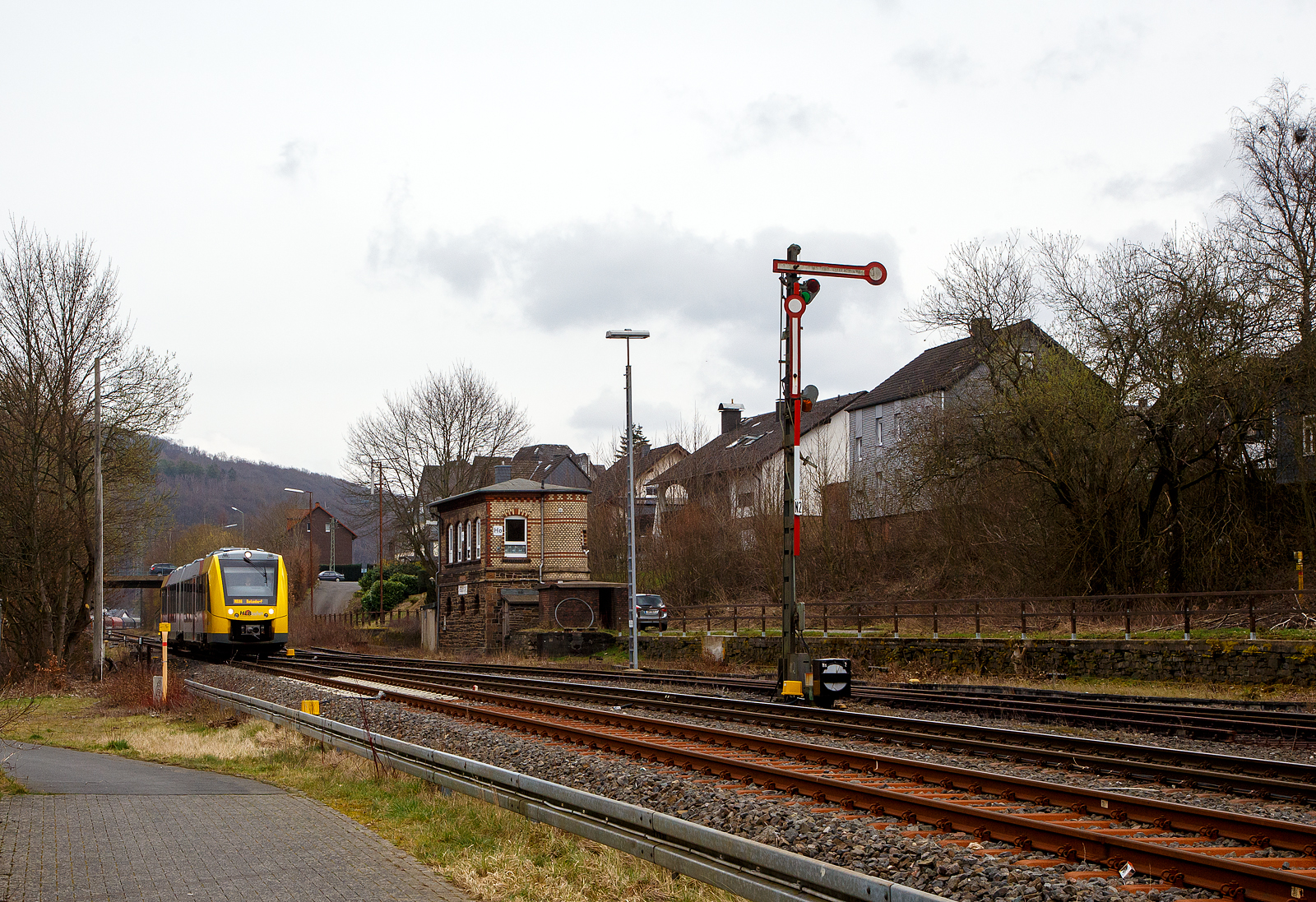 Nun fahren die Triebwagen der HLB RB 96 „Hellertalbahn“ auch endlich wieder den Bahnhof Herdorf an. Leider  ist aber dann in Herdorf am Hp Königstollen Schluss, ab dort gibt es dann von und nach Betzdorf (Sieg) SEV. Nach dem Hangrutsch (Felssturz) am 23. Dezember 2022 in Herdorf kurz hinter dem Hp  Königsstollen (bei km 88,4), ist der Abschnitt nach Betzdorf weiterhin bis mindestens bis zum kleinen Fahrplanwechsel am 11. Juni 2023, gesperrt. Aber diese ungewöhnliche Führung bis zum Hp  Königsstollen, über den Bahnhof Herdorf hinaus ist nötig, denn in den nächsten Tagen sollen die der Abriss und der Neubau der „Hellerbrücke“ der Hellerstraße (bei „Steinaus Eck“) beginnen und der SEV wäre so nur noch über Daaden oder Kirchen möglich.

Hier erreicht der VT 506 (95 80 1648 106-0 D-HEB / 95 80 1648 606-9 D-HEB), ein Alstom Coradia LINT 41 der neuen Generation / neue Kopfform, der HLB (Hessische Landesbahn GmbH) am 20.03.2023, als RB 96 „Hellertalbahn“ nach Betzdorf, bald den Bahnhof Herdorf.

Rechts das 1901 gebaute mechanische Weichenwärter Stellwerk Herdorf ost (Ho). Die beiden Stellwerke in Herdorf (Hf und Ho) sind in der Bauform Jüdel. Die Stellwerke der Bauform Jüdel (Max Jüdel & Co, Braunschweig) sind neben der Einheitsbauform am häufigsten in Deutschland anzutreffen. Viele andere Stellwerkshersteller haben Jüdel-Stellwerke in Lizenz gefertigt und dabei mehr oder weniger starke Änderungen vorgenommen.
