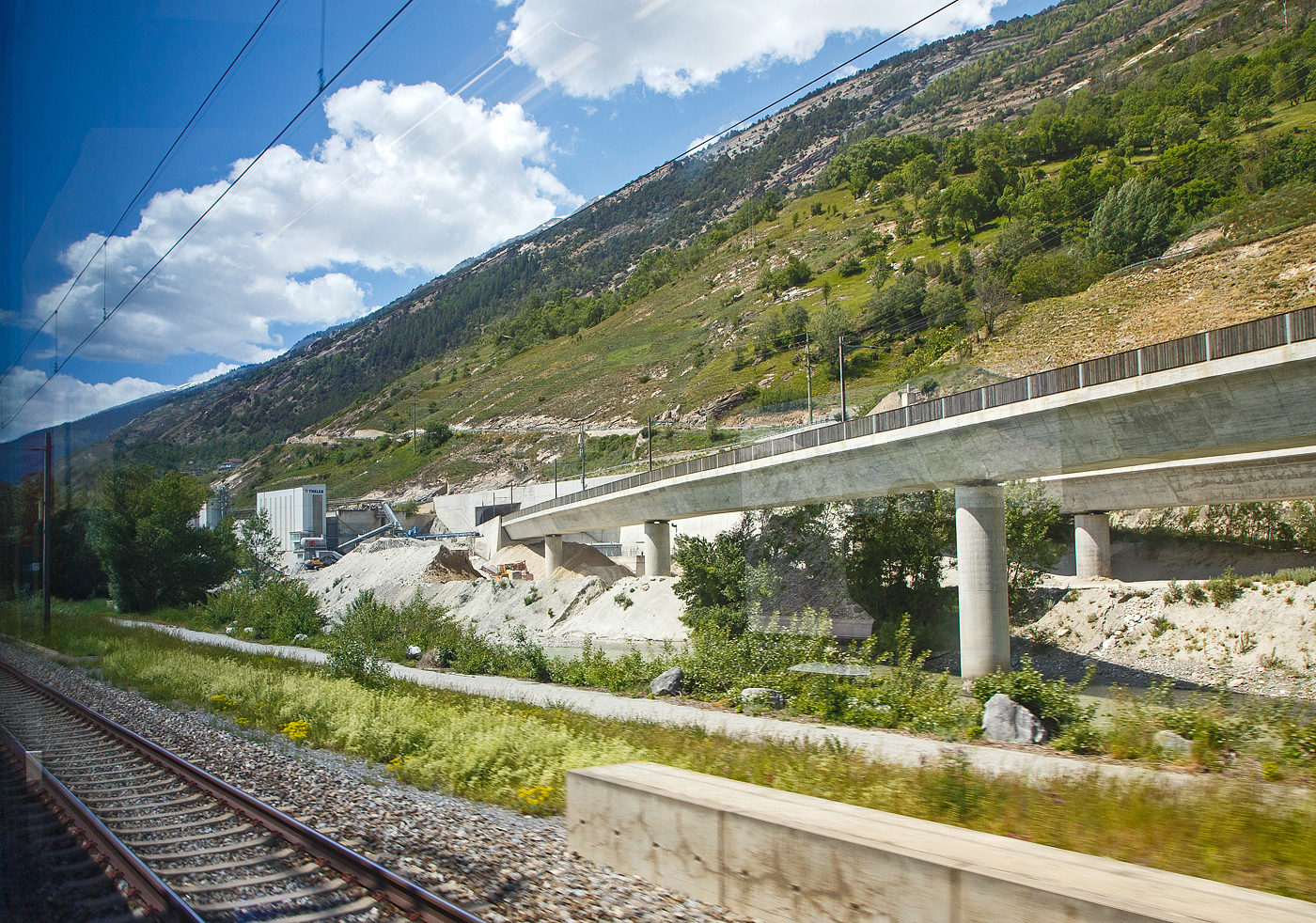 Südeinfahrt und –portal vom Lötschberg-Basistunnel bei Raron am 26.05.2023 aus einem IC heraus.

Der Lötschberg-Basistunnel ist ein 34,6 Kilometer langer Eisenbahntunnel, der zwischen Frutigen im Berner Oberland (Kanton Bern) und Raron (Kanton Wallis) am Lötschberg die nördliche Alpenkette unterquert und am 16. Juni 2007 in Betrieb genommen wurde. Dieser Basistunnel ist Teil der Lötschberg-Simplon-Achse der Neuen Eisenbahn-Alpentransversale (NEAT), die von Basel über Bern–Thun–Spiez zum Lötschberg und weiter via Brig–Simplon–Domodossola nach Mailand und Novara–Genua führt und neben der parallel verlaufenden Gotthardachse eine zweite Route für den alpenquerenden Schienengüterverkehr des Europäischen Korridors 24 (Rotterdam–Genua) bildet. Der Lötschberg-Basistunnel ist der fünftlängste Eisenbahntunnel der Welt, nach dem Gotthard-Basistunnel, dem Seikan-Tunnel, Eurotunnel und dem Yulhyeon-Tunnel. 

Der Basistunnel ist nur zu rund 40 Prozent zweispurig befahrbar. Auf einer Länge von 14 Kilometern wurde eine zweite Röhre zwar ausgebrochen, aber nicht für den Bahnbetrieb ausgerüstet. Weitere sieben Kilometer müssten noch ausgebrochen werden, damit die Züge den Tunnel durchgängig auf zwei Spuren befahren könnten. Wegen knapper Finanzmittel war der Tunnel in diesem reduziertem Umfang erstellt worden. Über den weiteren Ausbau laufen seit 2014 parlamentarische Beratungen.

Verlauf
Die beiden Röhren verlaufen in einem Regel-Achsabstand von 40 m und sind durch 104 Querschläge (mittlerer Längsabstand: 333 m) miteinander verbunden.

Die zulässige Höchstgeschwindigkeit im Basistunnel beträgt 250 km/h.Die Einmündung in die Rhonetalstrecke ist für 160 km/h ausgelegt, die Verknüpfung Wengi Ey für 120 km/h.
