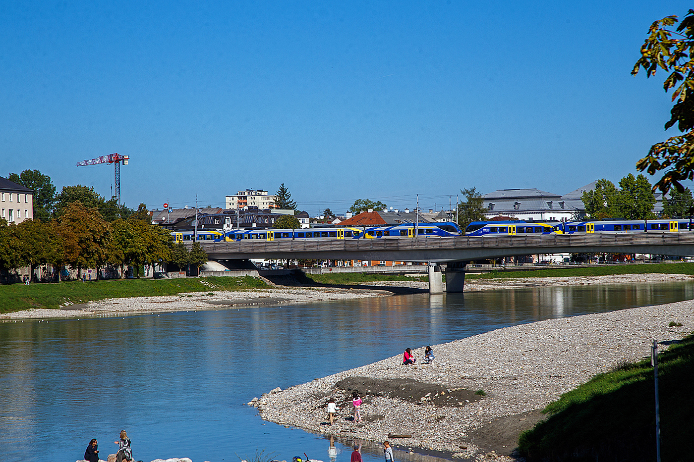 Zwei gekuppelte sechsteilige Stadler FLIRT³ der Baureihe 1430 der Bayerische Oberlandbahn GmbH überquert am 12.09.2022 in Salzburg die Salzach und erreicht bald, als RE 5 München – Salzburg, den Hauptbahnhof Salzburg.