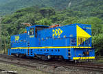 
Die stärksten Zahnradlokomotiven der Welt, die Stadler He 4/4 901502 der MRS Logística S.A. am 23.10.2012 solo bei Raiz da Serra. 
Das Bild wurde mir freundlicher Weise von Stadler Rail zugesandt und für eine Veröffentlichung hier überlassen.  

Die Stadler He 4/4 ist eine gemischte elektrische Zahnrad-Adhäsions-Lokomotive He 4/4 von den 2012 sieben Stück für MRS Logística S.A. in Brasilien gebaut wurden. Es besteht eine Option für drei weitere Lokomotiven.

Die MRS Logística S.A u.a. die  Eisenbahnlinie von Jundiaí  über São Paulo nach dem Hafen von Santos, das Einsatzgebiet der Loks ist der ca. 10 km lange Zahnstangenstrecke zwischen Raiz da Serra auf 17 m NN (ca. 20 km von Santos) nach Paranapiacaba auf 810 m NN. Die Maximale Neigung der Strecke beträgt hier 103 ‰. Die Strecke mit einer Spurweite von 1.600 mm (Irische Breitspur) ist hier mit einer Zahnstange des Systems Abt mit drei Lamellen je 60 mm Breite und mit einer Oberleitung mit 3000 Volt Gleichstrom ausgerüstet.  Das Lichtraumprofil der Lokomotiven ist größer als bei den anschließenden Adhäsionsstrecken, so dass die Lokomotiven nur zwischen Raiz da Serra und Paranapiacaba eingesetzt werden und die Hauptwerkstätten der MRS Logística S.A. nicht ohne weiteres erreichen können. Sie haben deshalb vor Ort eine eigene Werkstätte.

Das Transportvolumen der Strecke beträgt ca. 14 Mio. Bruttotonnen im Jahr (das entspricht etwa der Hälfte des Gotthardtunnels). Das Transportgut fällt überwiegend talwärts an, zu 80 % handelt es sich um Eisenerz sowie landwirtschaftliche Produkte. Da nur die Lokomotiven mit Bremszahnrädern ausgerüstete sind, befinden sich diese aus Sicherheitsgründen immer auf der Talseite. Das heißt also, die Züge werden die Strecke hinauf geschoben. Die alten Hitachi Lokomotiven dürften aus Sicherheitsgründen nur in Doppeltraktion verkehren.

Es ist eine Doppeltraktion zweier Lokomotiven vorgesehen. Dies erlaubt, als Vorstelllast einen Zug mit einem Gewicht von 850 Tonnen zu befördern. So werden mit diesen Lokomotiven 50 % mehr Last, bei höherer Geschwindigkeit, als mit den über 40 Jahre alten Lokomotiven von Hitachi gebaute Lokomotiven transportiert.  Einzel kann eine Stadler He 4/4 einen 750 t Zug befördern.

Die speziell für den harten Betriebseinsatz (7 Tage/Woche,24 h)  von Stadler entwickelten Lokomotiven verfügen über eine Leistung von 5.000 kW, die Fahrleitungsspannung  beträgt  3kV  DC,  die Bremsenergie  kann  rekuperiert  werden. Die Lage des Zahnrades kann entsprechend der Abnützung der Räder nachgestellt werden

Die gemischte Zahnrad-Adhäsion-Lokomotive Stadler He 4/4 hat zwei zweiachsige einzelachsangetriebene Drehgestelle mit zusätzlich je zwei Antriebszahnrädern, also mit der Achsfolge Bozz' Bozz'. Jedes Drehgestell hat somit zwei Adhäsion- und Zahnradmotoren. Jede Lok besteht elektrisch aus zwei unabhängigen Antriebseinheiten, so ist eine hohe Redundanz gegeben. Zudem erfolgt eine Rückspeisung des Bremsstroms in die Oberleitung.

Die Lokomotive besitzt einen Mittelführerstand mit zwei schmäleren Vorbauten. Der klimatisierte Führerstand hat eine Fußbodenhöhe von 2.450 mm und ist damit so hoch wie möglich angeordnet, damit der Lokomotivführer bei Bergfahrt über die vorgestellten Wagen blicken kann. Der Lokomotivführer sitzt vor einem quer zur Fahrrichtung eingebauten Führerpult und kann seinen Sitz in die Fahrtrichtung drehen. Auf jedem Vorbau ist über dem Drehpunkt des Drehgestells jeweils ein mit drei Schleifstücken versehener Stromabnehmer montiert. Die Vorbauten sind um die Höhe des abgesenkten Stromabnehmers niedriger als das Führerhaus ausgeführt. Damit liegen Vorbauten, Stromabnehmer und Führerhaus im gleichen Lichtraumprofil.

Die Lokomotive besitzt für jede angetriebene Achse und jedes Zahnrad einen eigenen Motor, es gibt somit insgesamt acht Fahrmotoren. Bei der Fahrt im Zahnstangenabschnitt arbeiten die Adhäsionsmotoren mit und erbringen so rund 25 % der Zug- oder Bremskraft. Die Primärfederung ist wegen des Zahnradantriebes sehr steif ausgeführt. Die Höhe des Zahnradeingriffes kann durch Unterlegen von Beilageplatten an die Abnutzung der Antriebsräder angeglichen werden. Die Drehgestelle sind verwindungsweich ausgeführt und besitzen Gleitlager am mittleren Querträger. Der Rahmen der Lokomotive ist auf eine Längsdruckkraft von 5.000 kN ausgelegt.

Bergseitig ist die Einspeisung von einer externen Diesel- Generatorgruppe möglich. Damit kann der Gleisunterhalt mechanisiert und Fahrdrahtunabhängig durchgeführt werden.

TECHNISCHE DATEN der He 4/4:
Nummerierung: 	901501–901507
Anzahl: 7
Hersteller: 	Stadler Rail
Baujahre: 	2012
Spurweite: 	1.600 mm (Irische Breitspur)
Achsformel: Bozz' Bozz'
Länge über Kupplung: 18.720 mm
Höhe: 4.600 mm
Breite: 3.280 mm
Drehzapfenabstand: 	8.300 mm
Achsabstand im Drehgestell: 5.000 mm (Zahnräder  3.420 mm)
Dienstgewicht: 121 t
Höchstgeschwindigkeiten: 60 km/h (Zahnrad bergwärts 30 km/h, talwärts 25 km/h)
Leistung am Rad: 5.000 kW
Anfahrzugkraft: 760 kN (Adhäsion 240 kN, Zahnrad 520 kN)
Dauerzugkraft:  540 kN
Treibraddurchmesser: 	1.069 mm (Neu)
Zahnradsystem: 	Abt dreilamellig je 60 mm Breit
Anzahl Antriebszahnräder: 	4
Größe Zahnräder: 1.031 mm
Stromsystem: 3000 Volt =
Stromübertragung: Oberleitung
Gefälle: 104 ‰
Kupplung: Standard AAR-Kupplungen

Quelle Stadler Rail und Wikipedia. 
Dank an Stadler Rail

